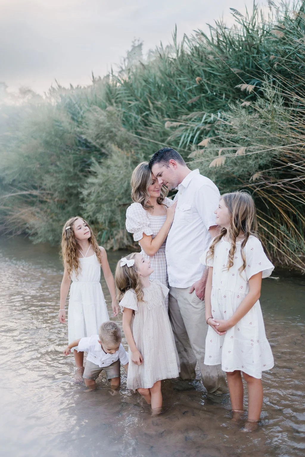 Adventure family photography capturing a playful family exploring and splashing together in a Southern Utah river. This unique St. George family photoshoot combines beautiful scenery, genuine connection, movement, and candid moments to create unforge