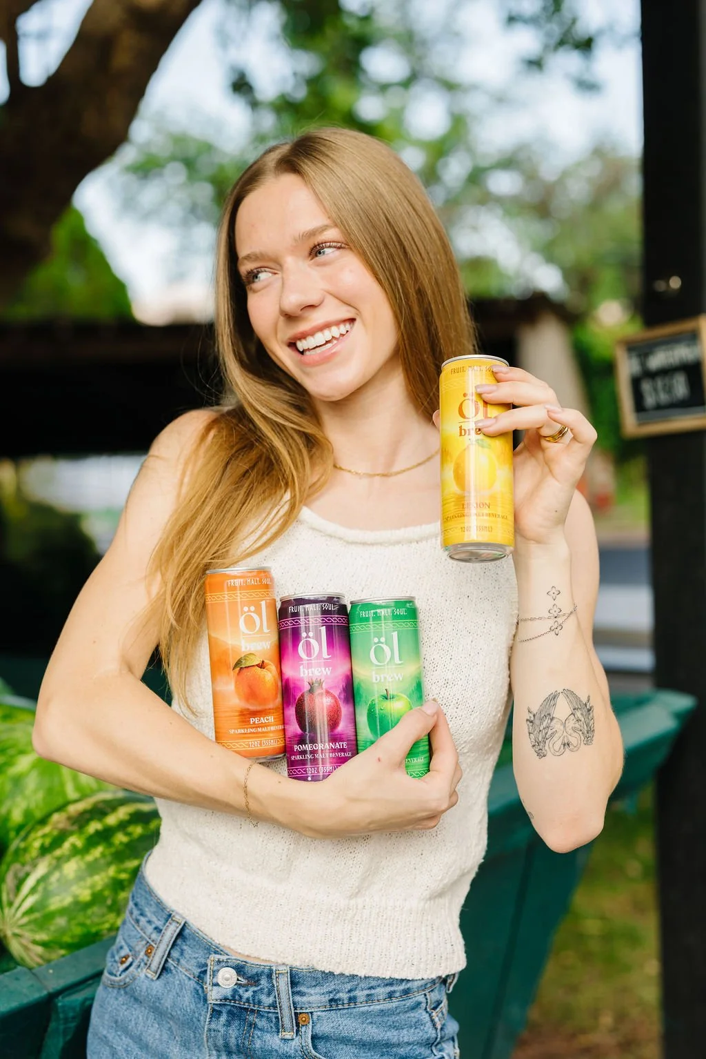 Commercial product and lifestyle photography in St. George, Utah featuring a model showcasing colorful canned beverages. This branding photoshoot creates bright, engaging content for beverage companies, food brands, and consumer products through natu