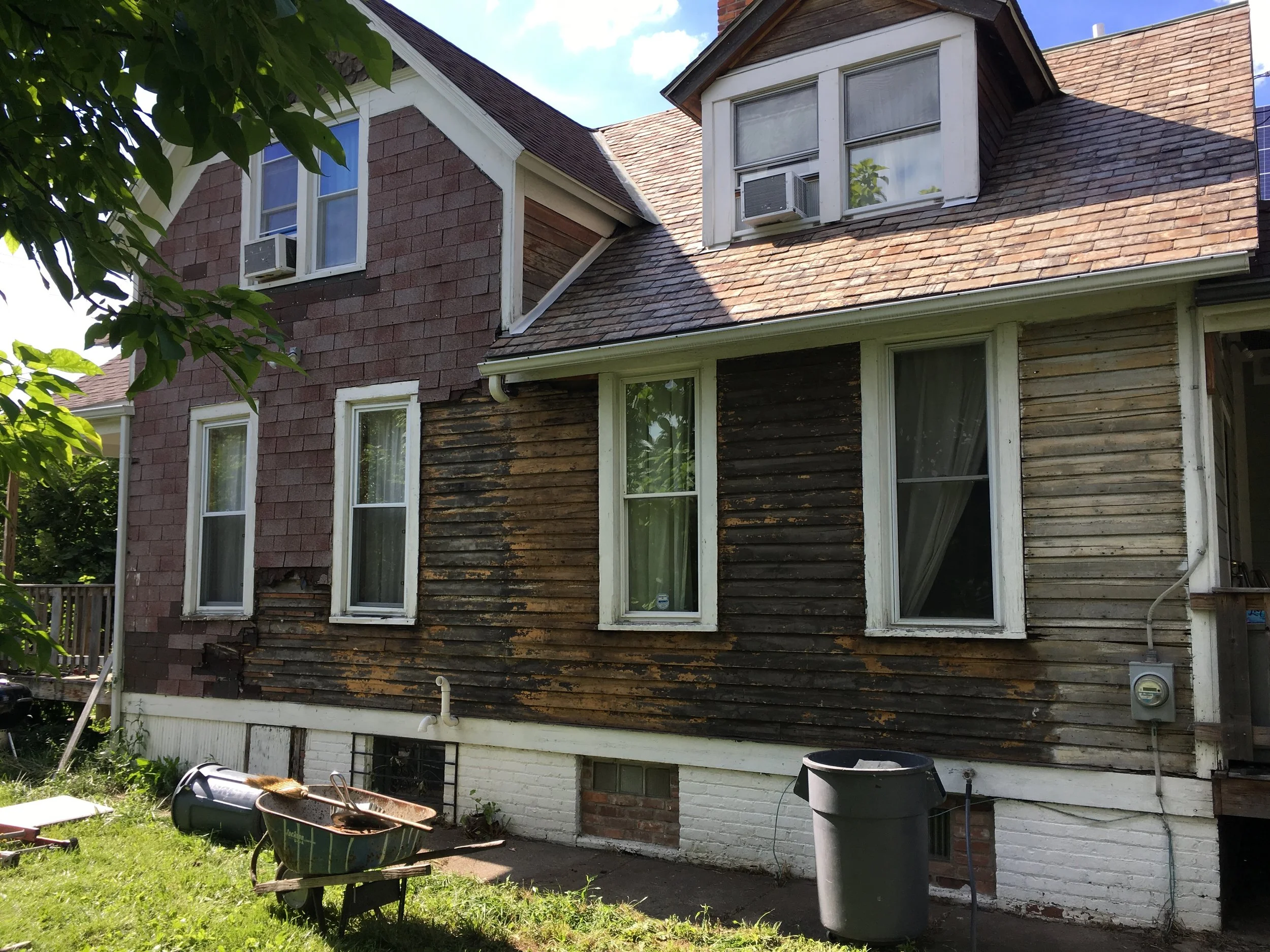 South side under construction, in process of removing two layers of roofing shingles used as siding