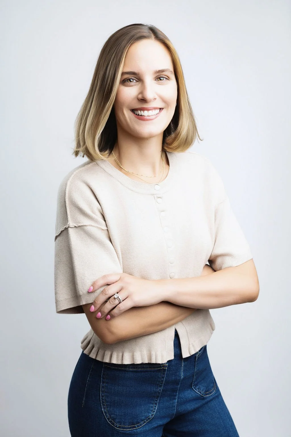 Headshot of smiling female tutor with short blonde hair wearing a lanyard.