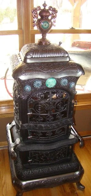 Sterling Ventilator Baseburner with five tiles and an ornate finial that has two tiles, one in front one in back. $6250