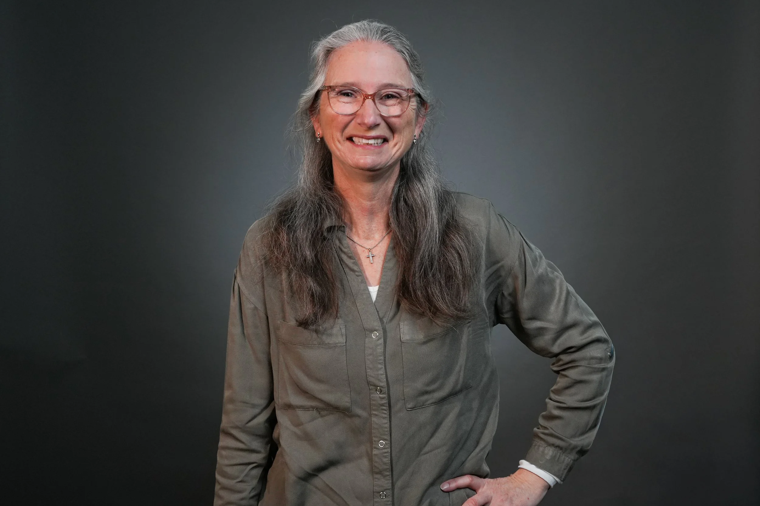 Smiling woman in maroon sweater against gray background