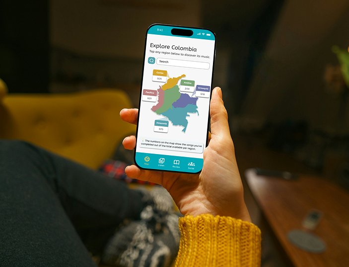 A person holding a smartphone displaying a map of Colombia with region names and numbers, in a cozy indoor setting.