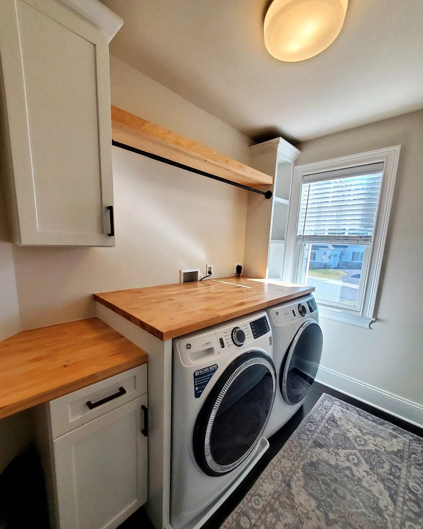 built in shelving, folding station and hanging rail in a laundry room