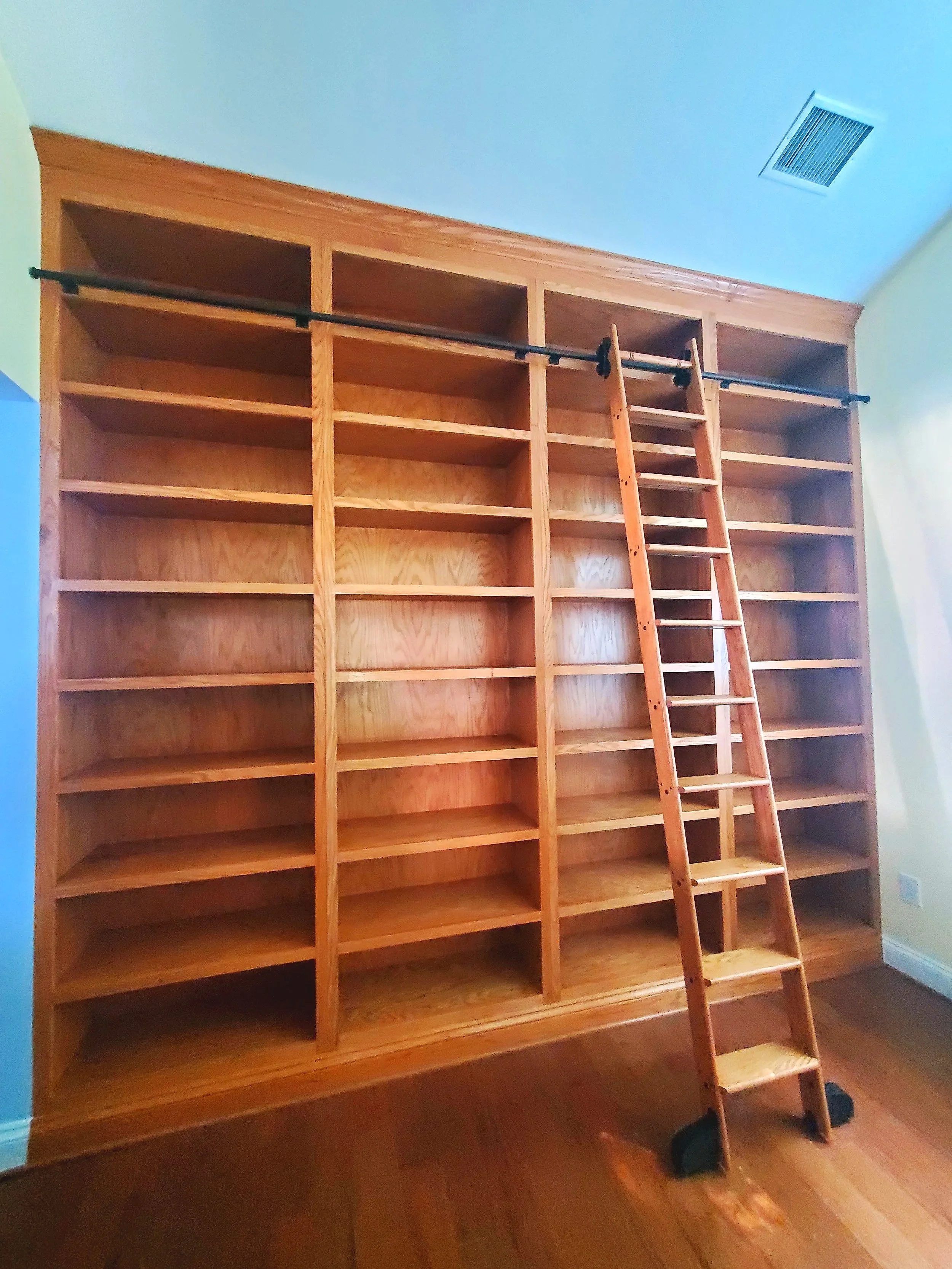 Custom floor to ceiling bookshelf with matching ladder