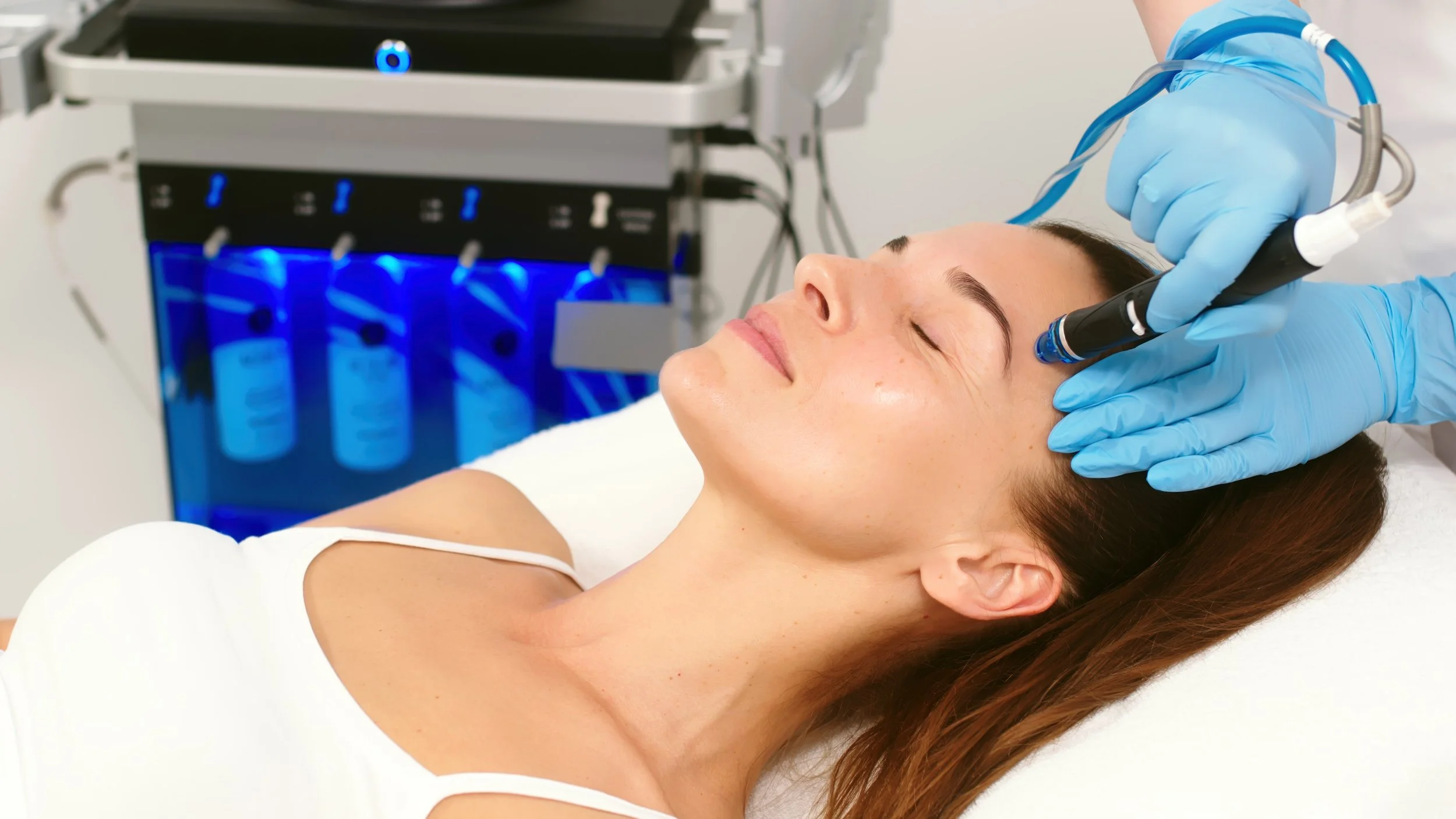 Woman receiving a hydrating facial for refreshed, glowing skin before holiday parties and photos.