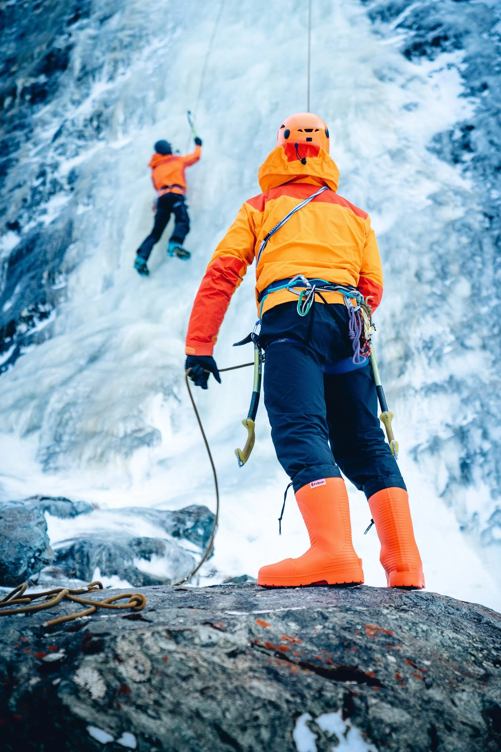 two climbers support each other in a difficult climb, a metaphor for why collaborative approaches are better than combative ones