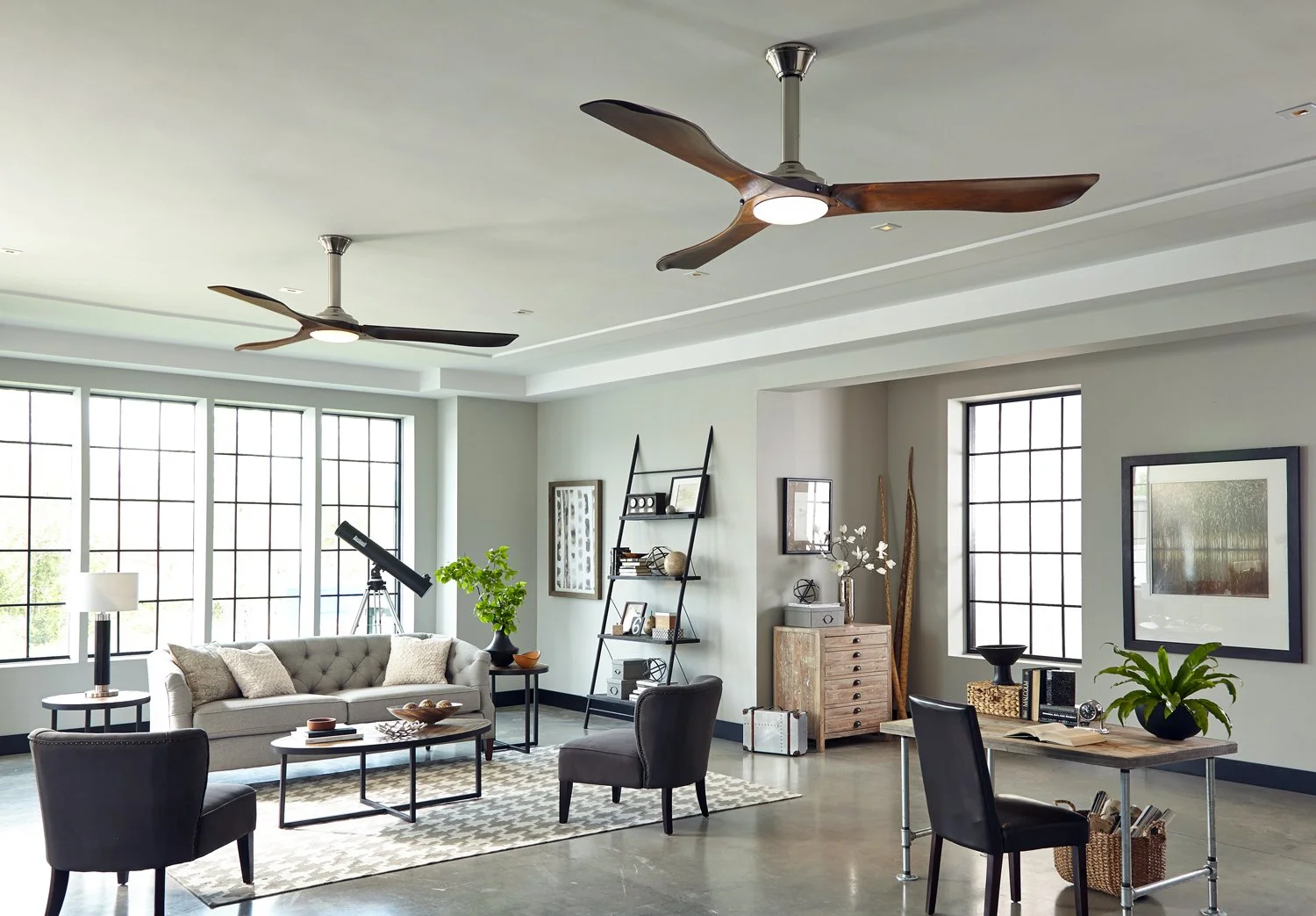 Modern living room with sleek ceiling fans, gray sofa, telescope, and stylish decor accents.