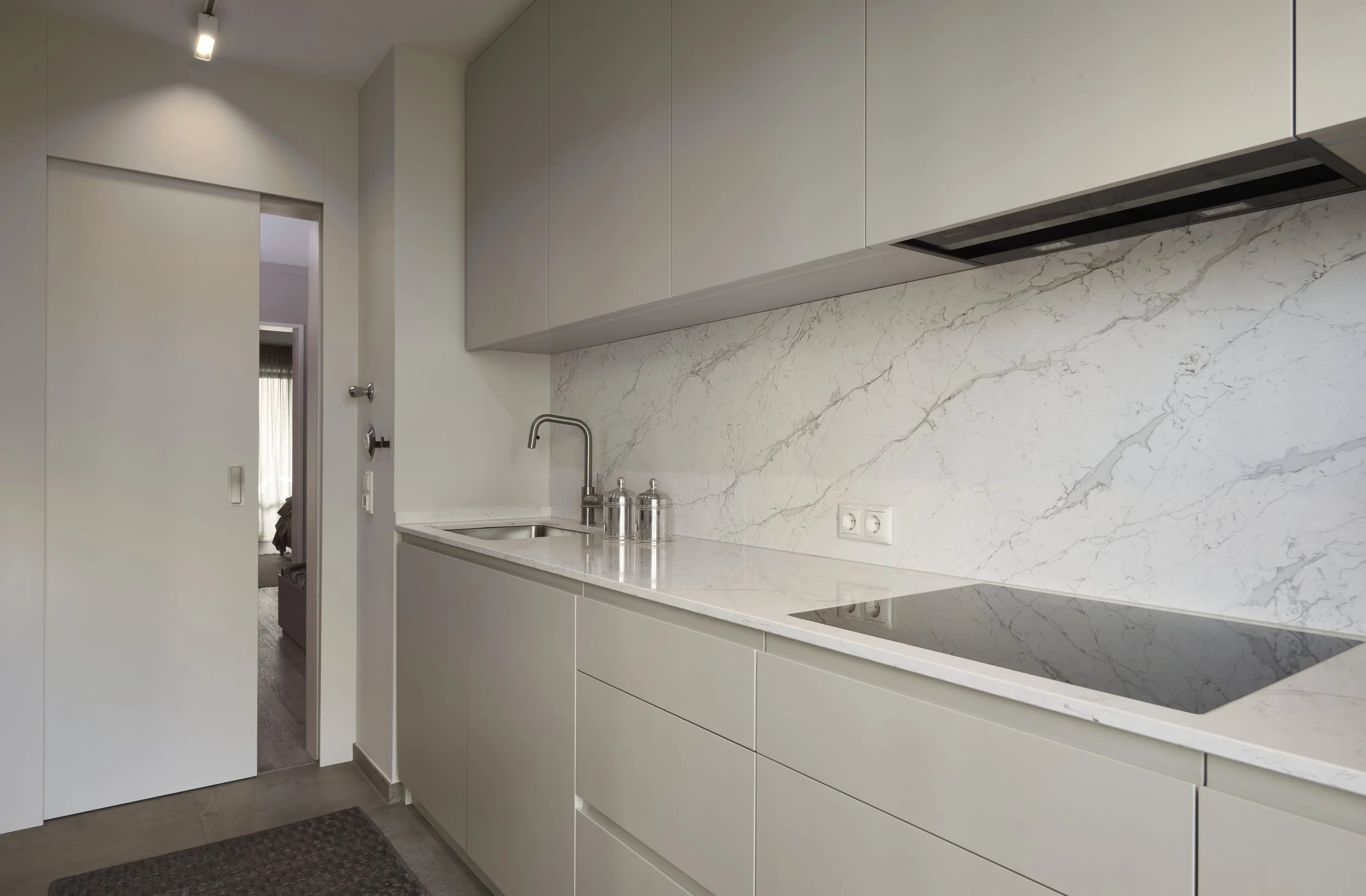 Küche modern hell Kunststein Arbeitsplatte Spritzschutz Tischleranfertigung Oberschränke Schiebetür