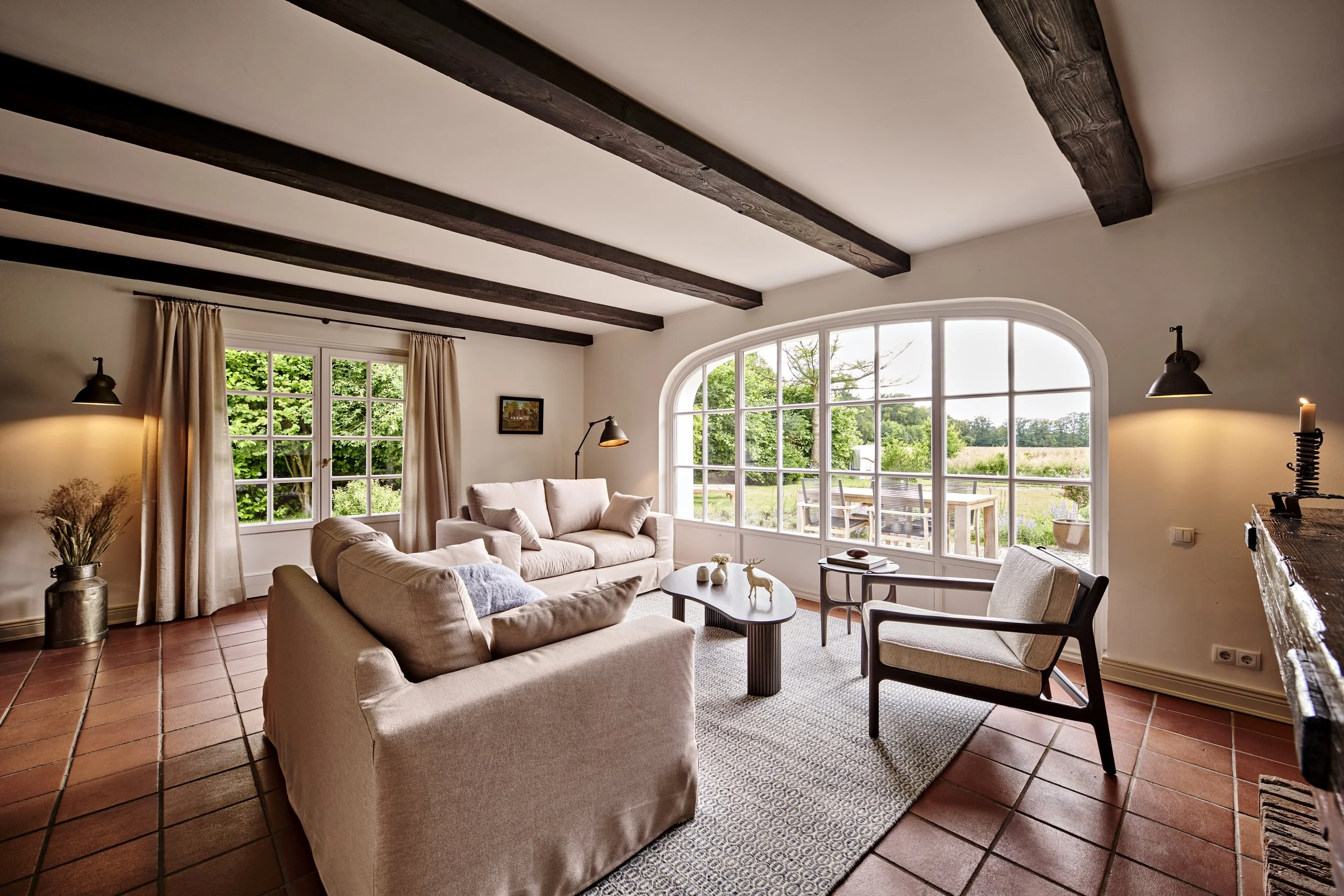 Wohnzimmer Sofas beige Holzbalken dunkelbraun Sessel Ethnicraft Landhausstil