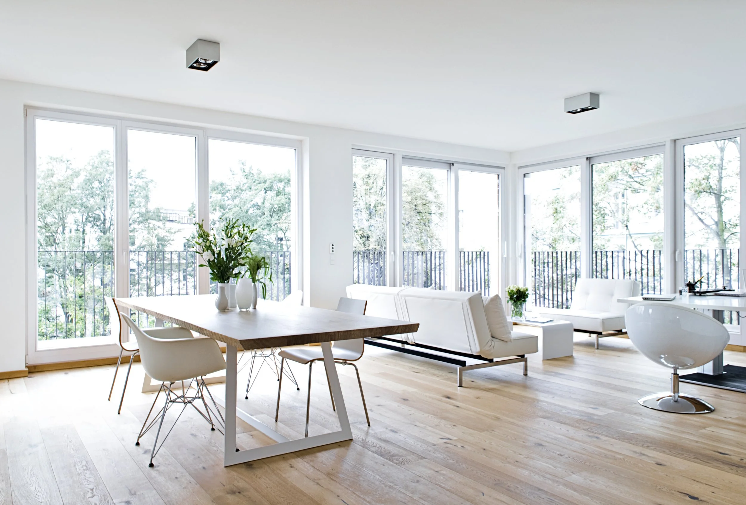 Wohn- Essbereich offen Parkettboden Möbel weiss Tisch Eiche Metall weiss Stühle Eames weiss 