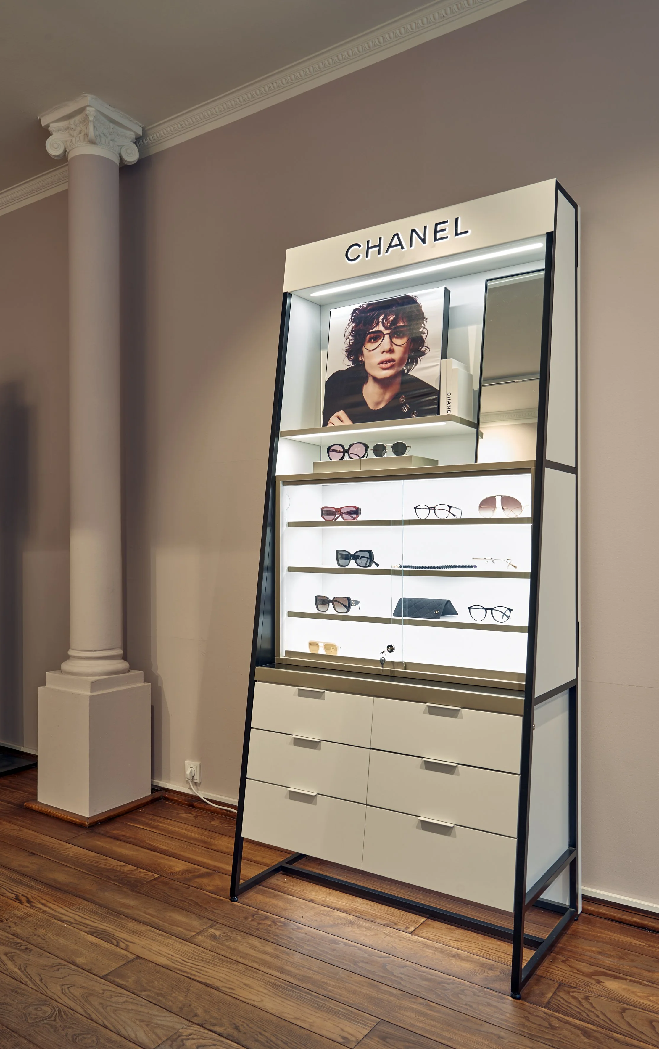 Brillenfachgeschäft Augenblick Display Schaukasten Chanel Holzdielenboden Säule weiss