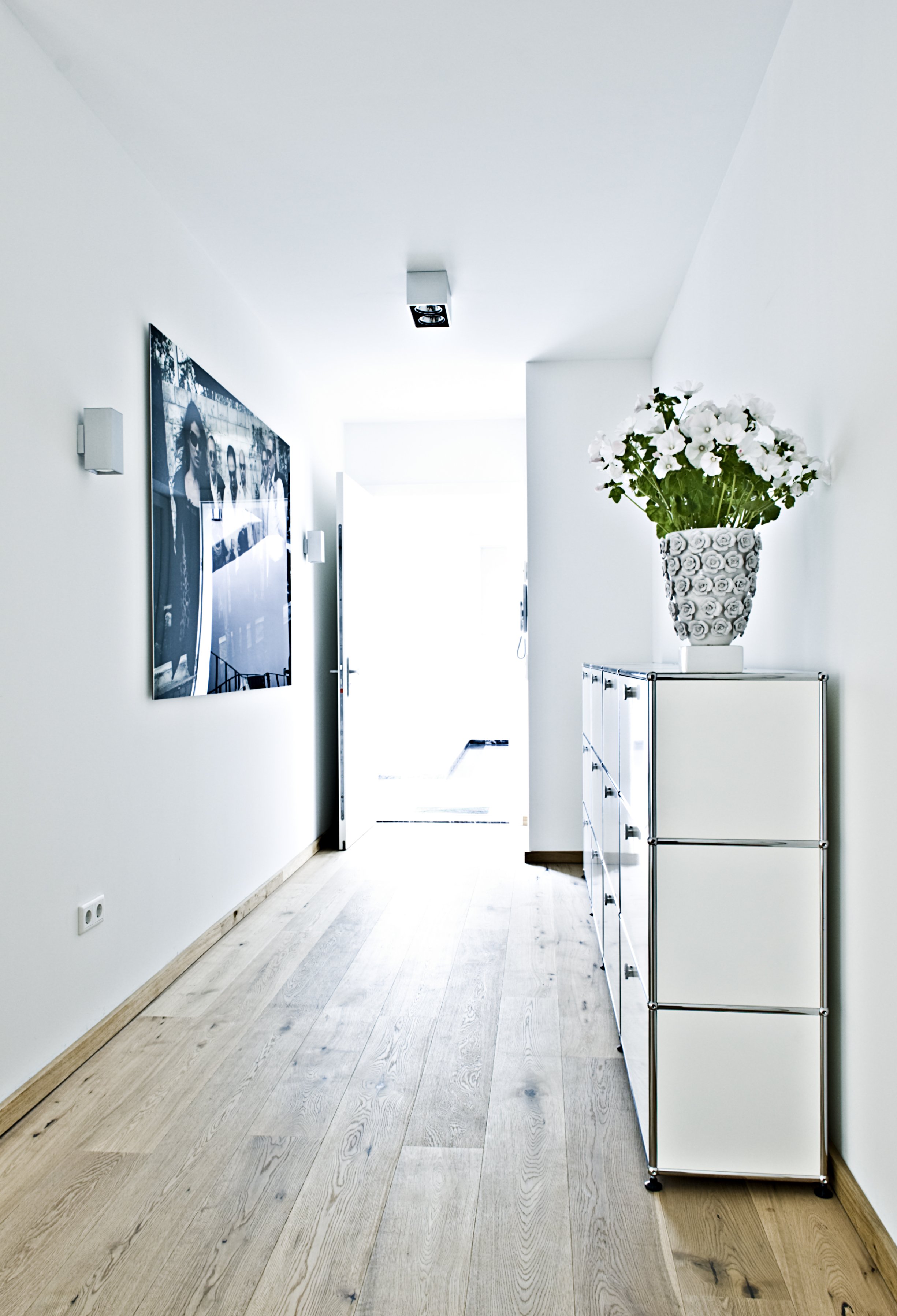 Flur Eingangsbereich Parkettboden USM Haller Sideboard weiss Kunst Dekoration Blumenvase weiss