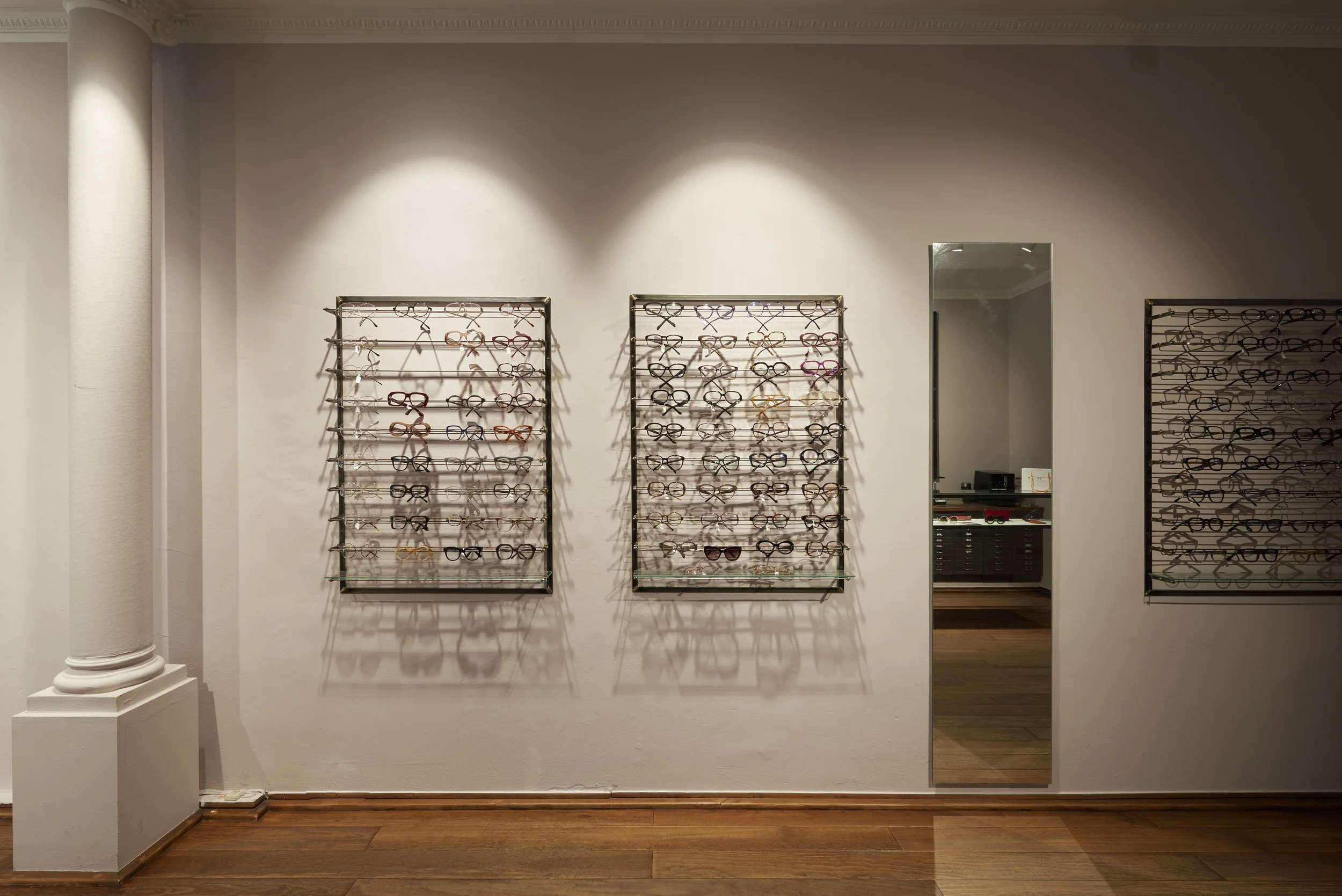 Brillenfachgeschäft Augenblick Holzdielenboden Schienensystem weiss Beleuchtung Säule weiss 