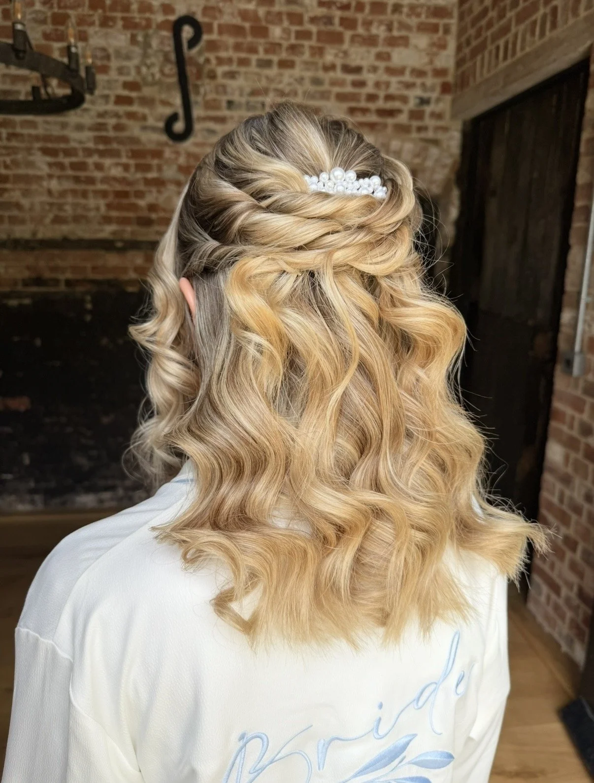 The back of a brides head showing her curly hairstyle with hair accessorie