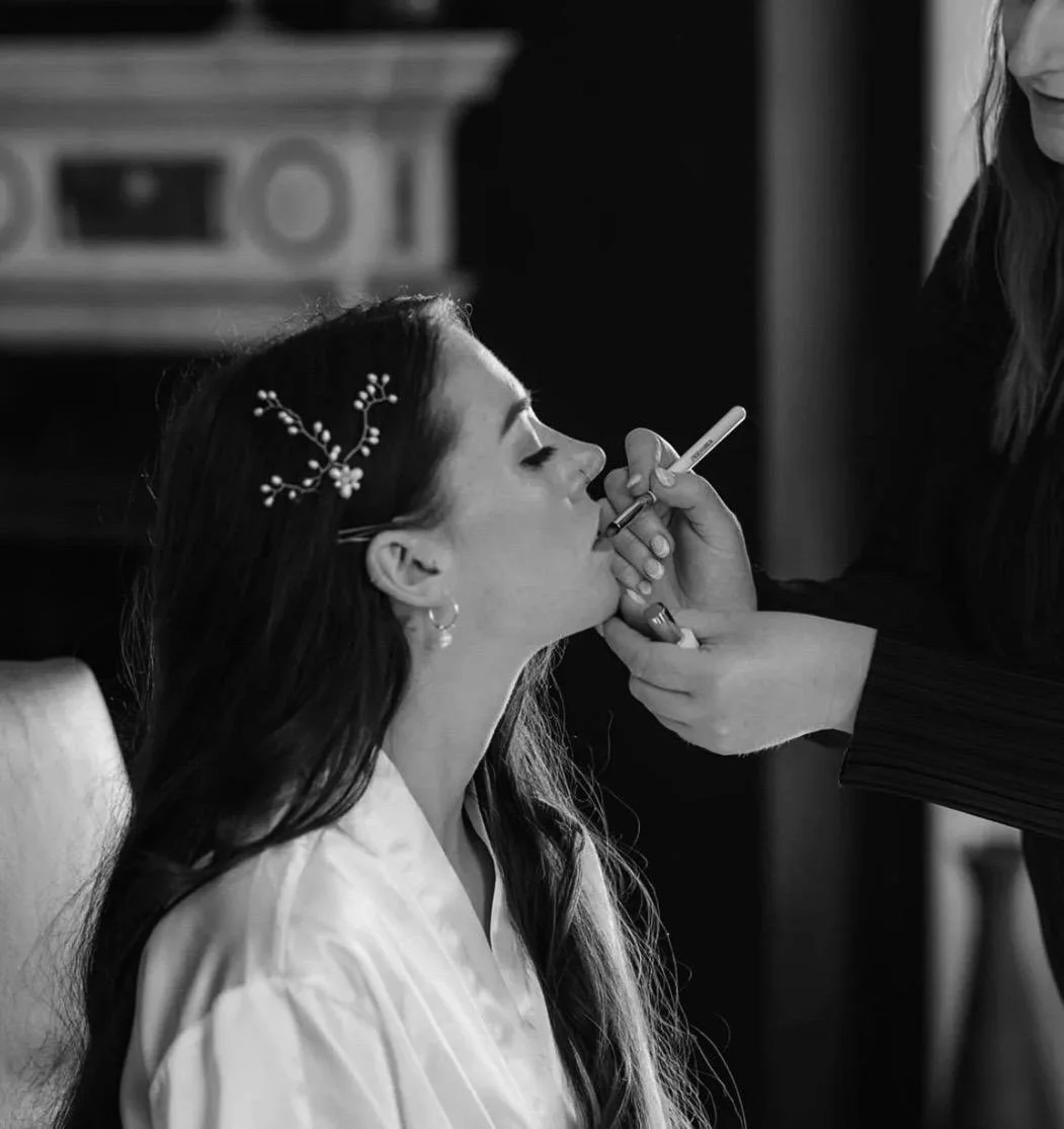 A bride having lipstick applied to her lips by a Hampshire based makeup artist.