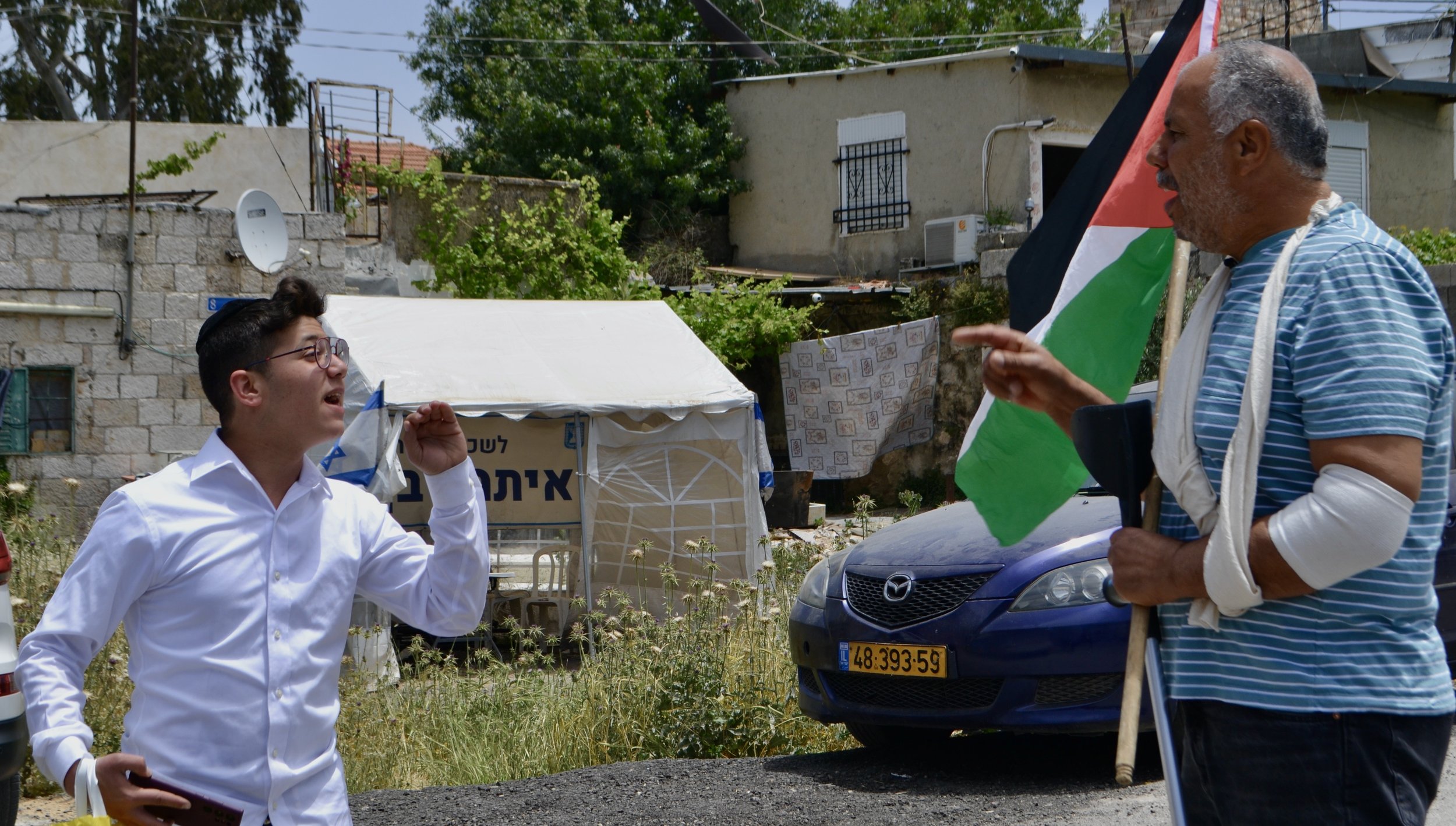  sheikh jarrach may 2022.  Abu Moussa in discussion with a Jewish student, directly in front of the tent office of Itamar Ben-Gvir. 