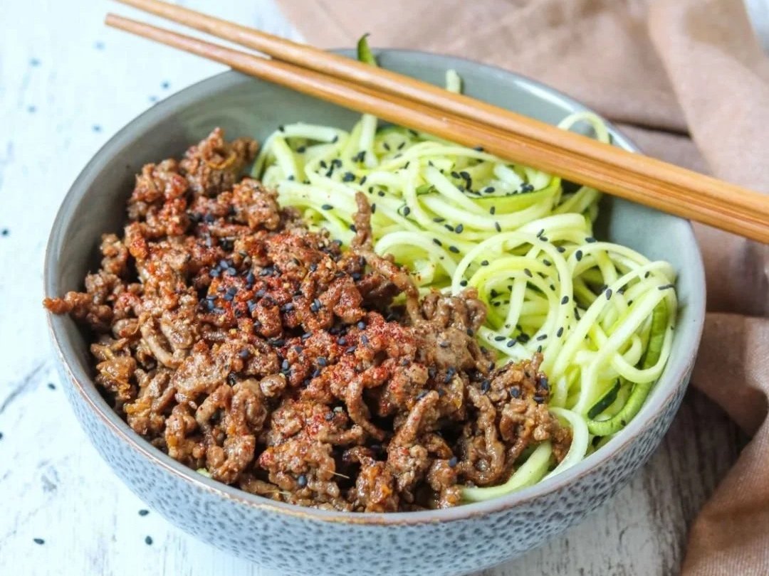 Ground beef in sesame ginger sauce over zucchini noodles