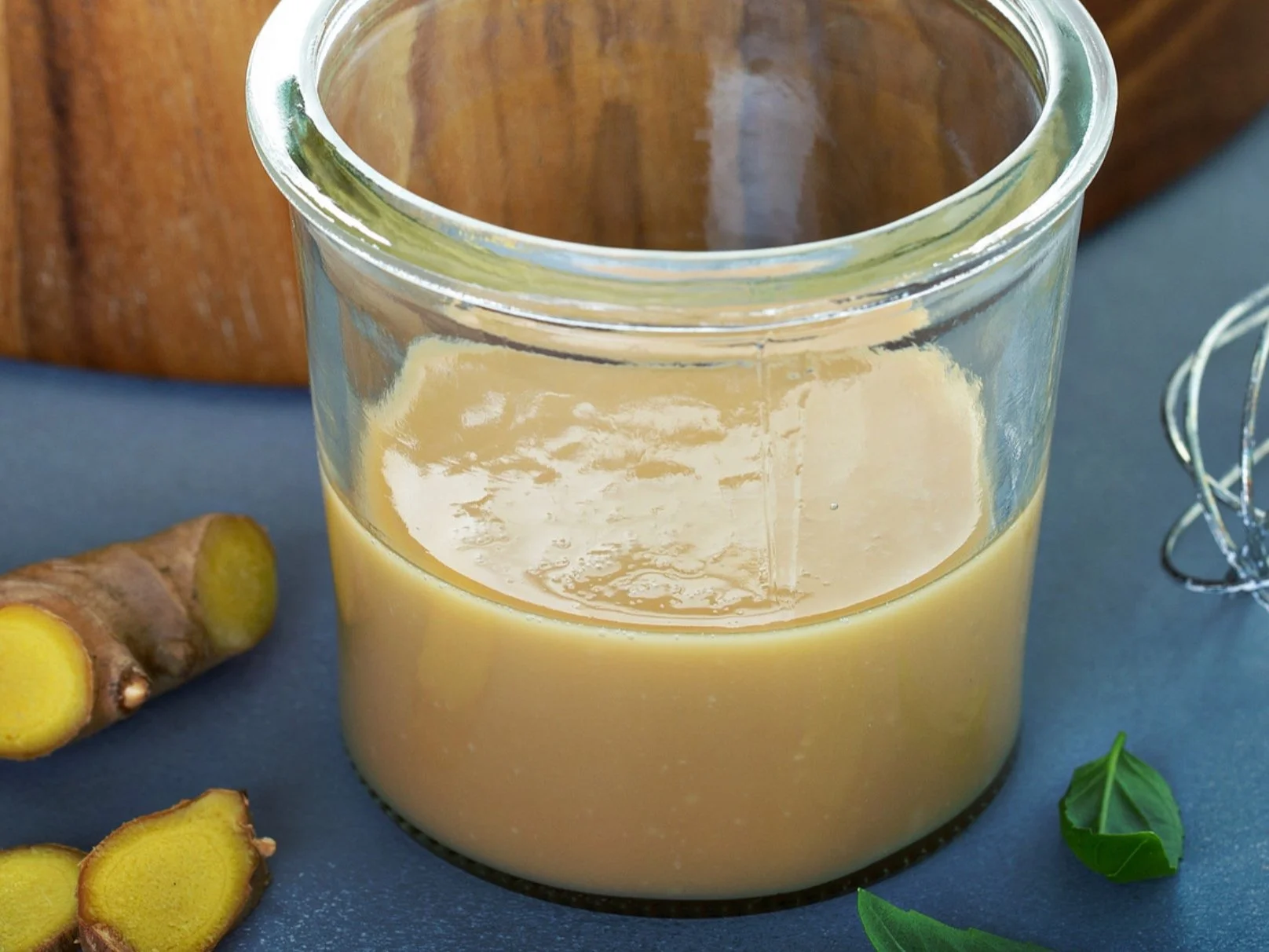 A jar of sesame ginger dressing with fresh ginger and sesame seeds