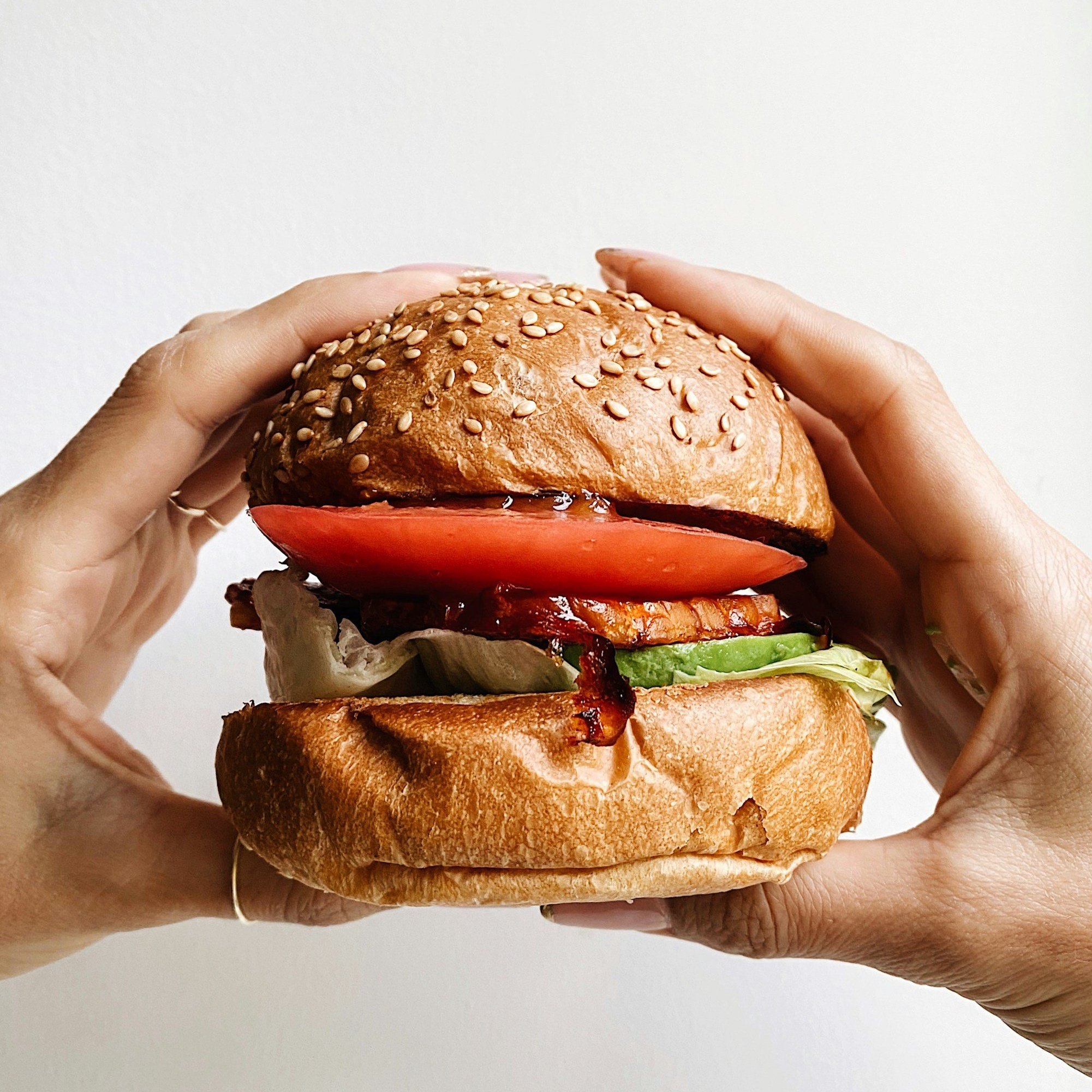 Hands holding a burger, the meal that can start a food spiral