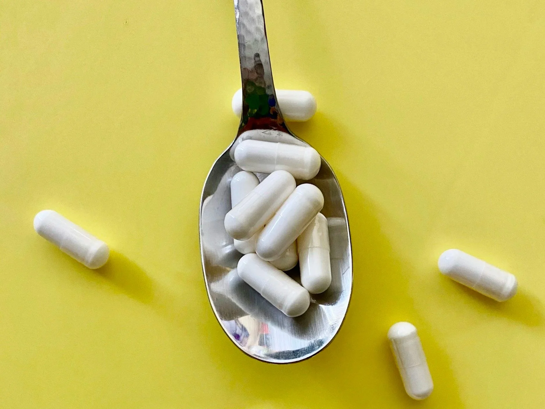 Magnesium supplement capsules on a spoon