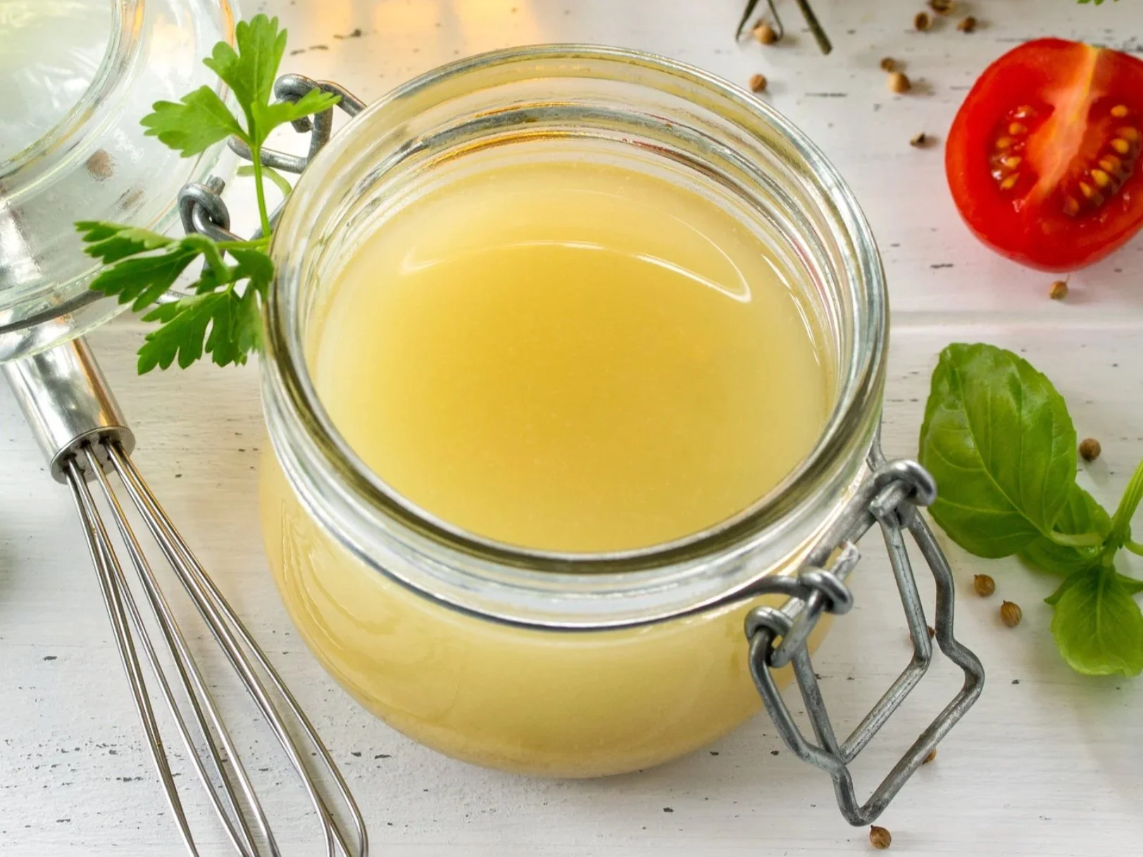 A small glass jar of lemon olive oil dressing