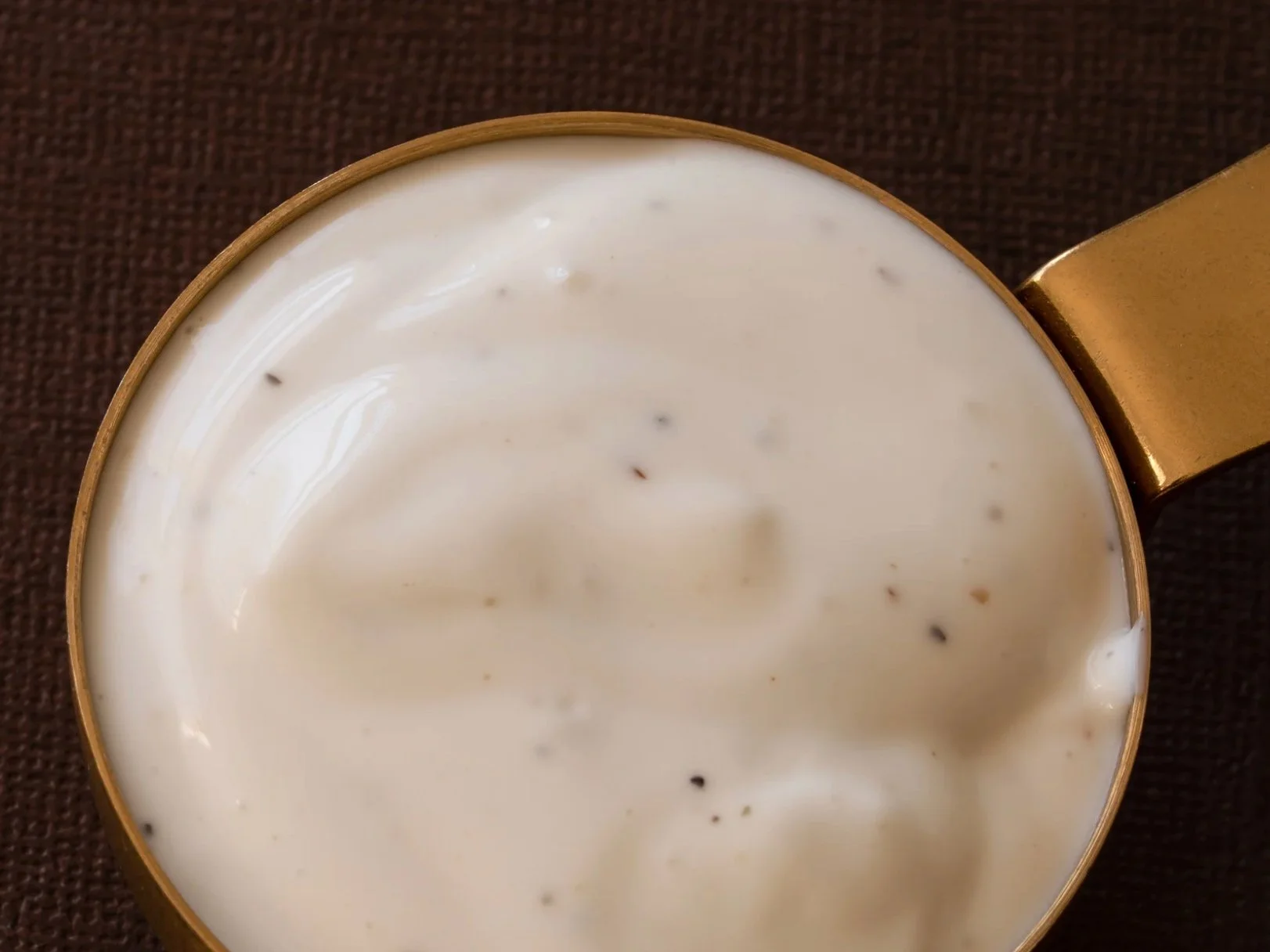 A bowl of ranch dressing with fresh dill and chives