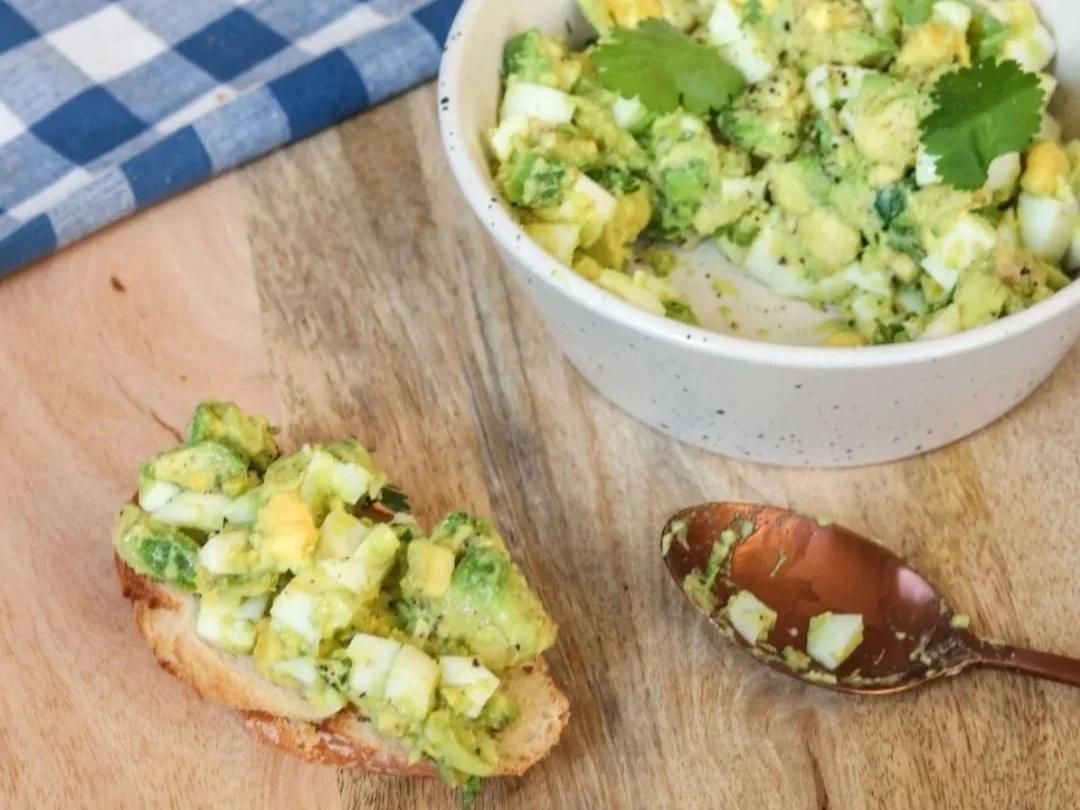 Chopped egg and avocado paste with fresh coriander on a slice of sourdough bread