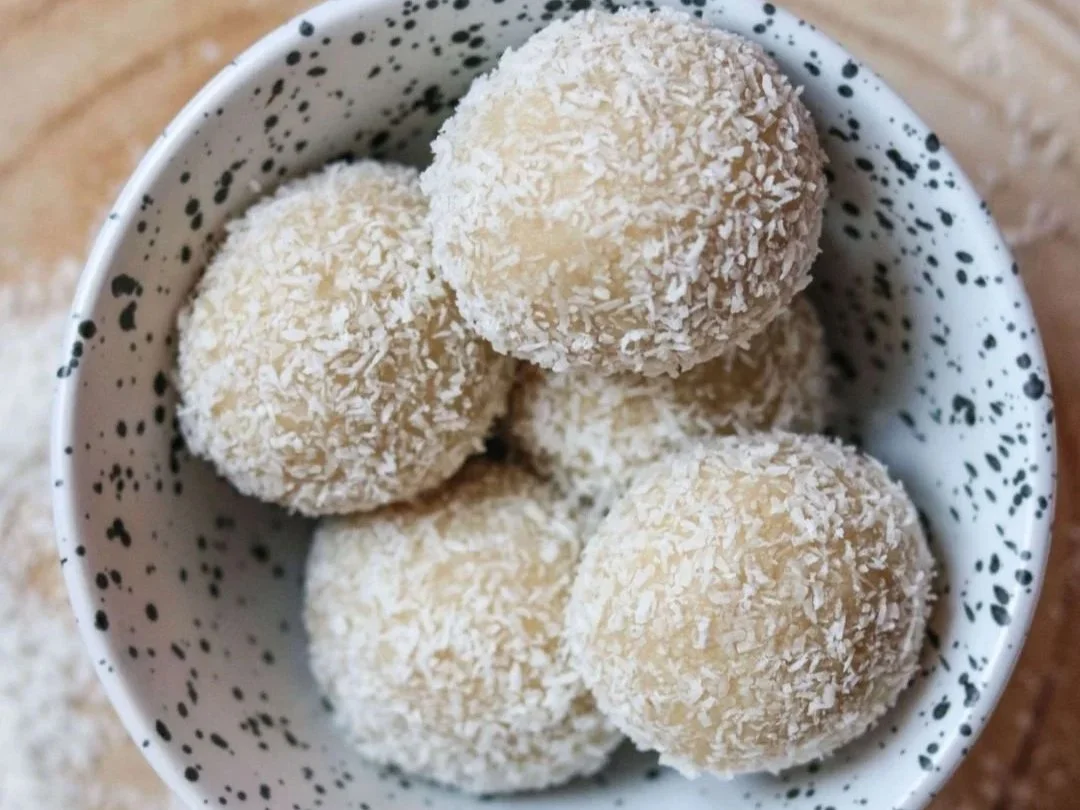 Almond energy balls with coconut flakes in a bowl