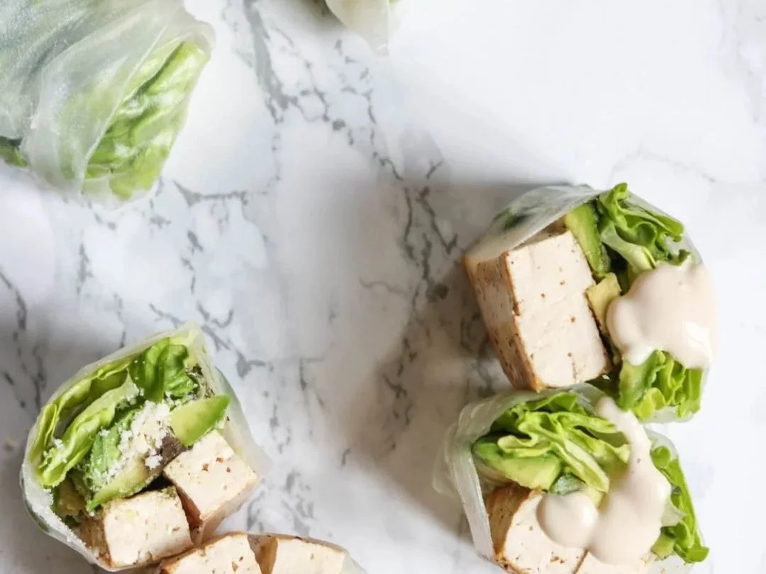 Tofu caesar summer rolls with lettuce and avocado on marble background
