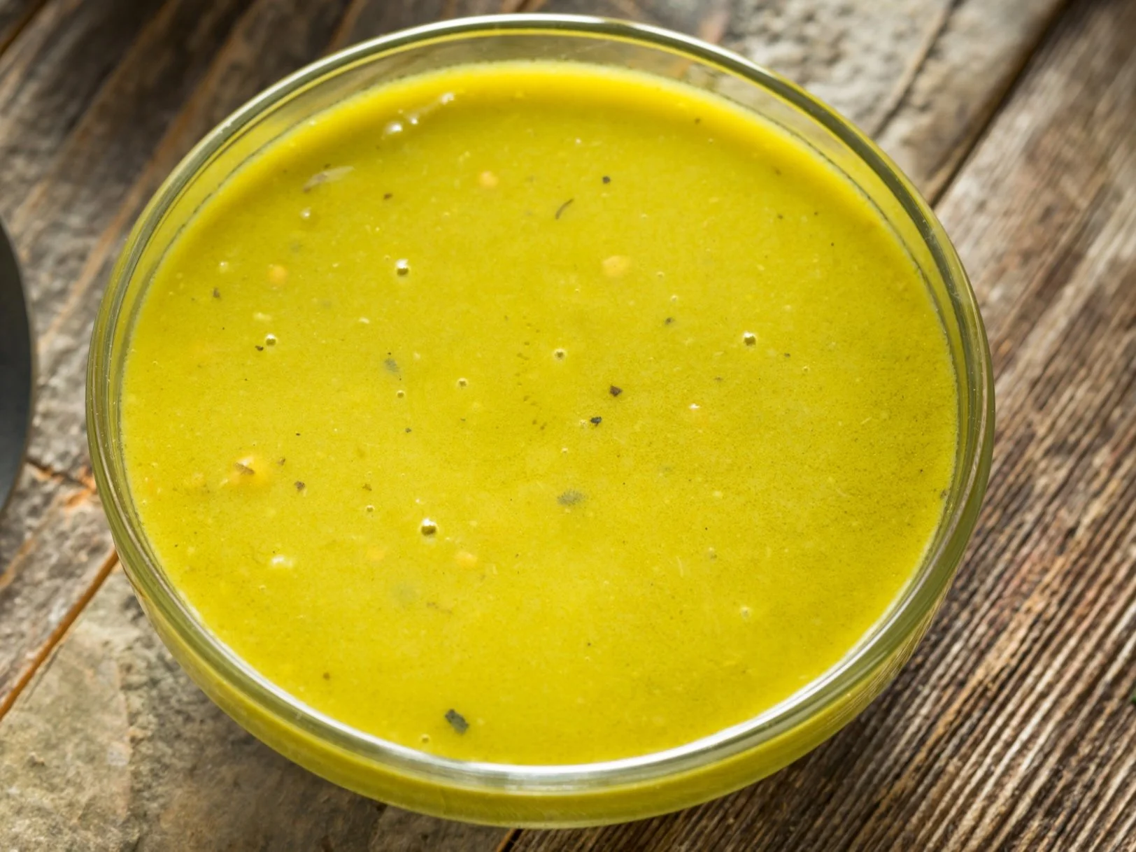 A glass bowl of green goddess dressing with fresh herbs