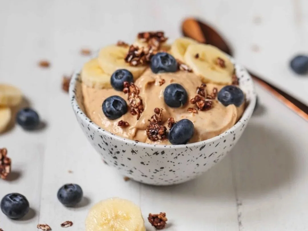 Peanut butter protein fluff with blueberries, banana, and low-sugar granola in bowl