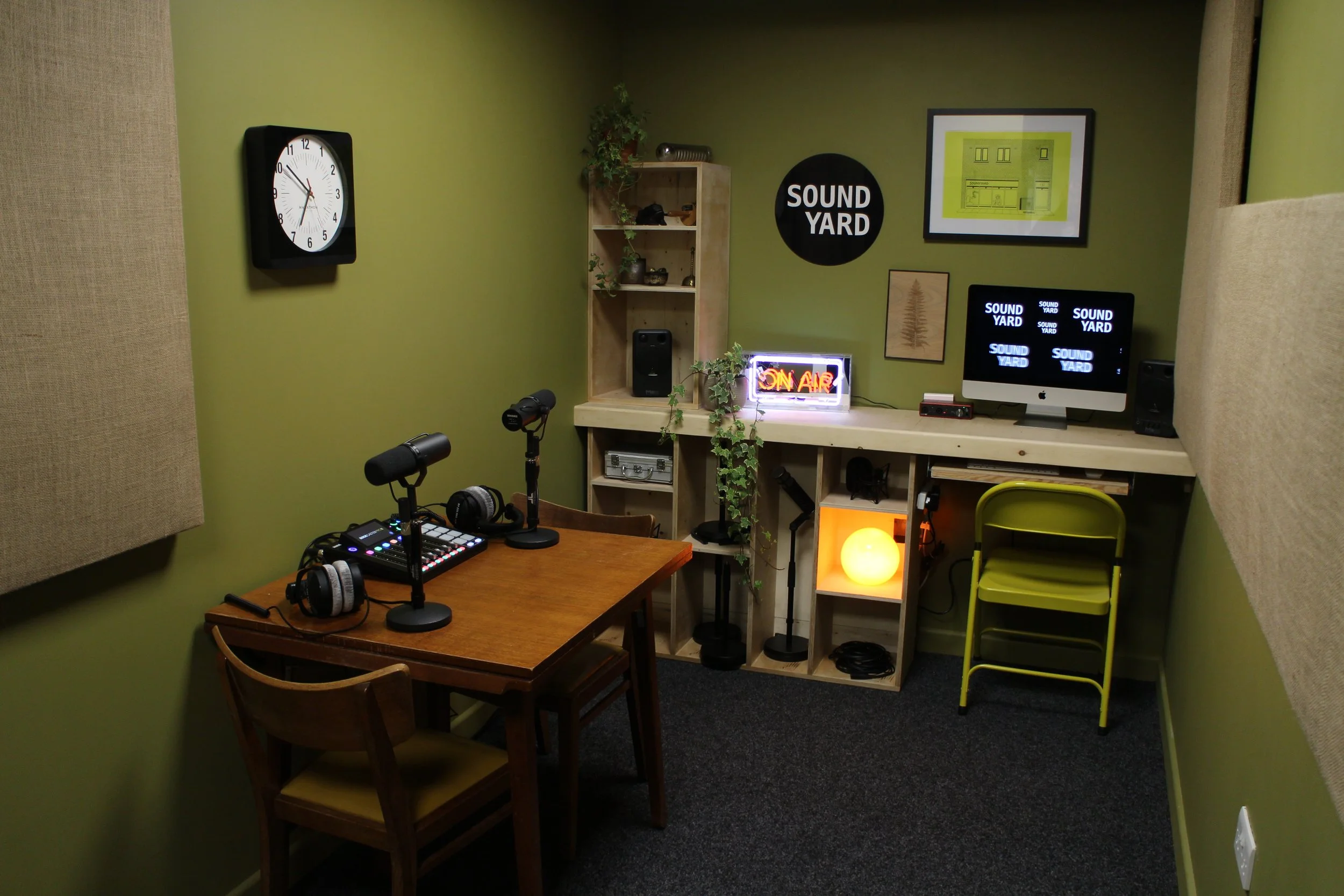 Soundyard Norwich podcast room with table, microphones and ON AIR sign