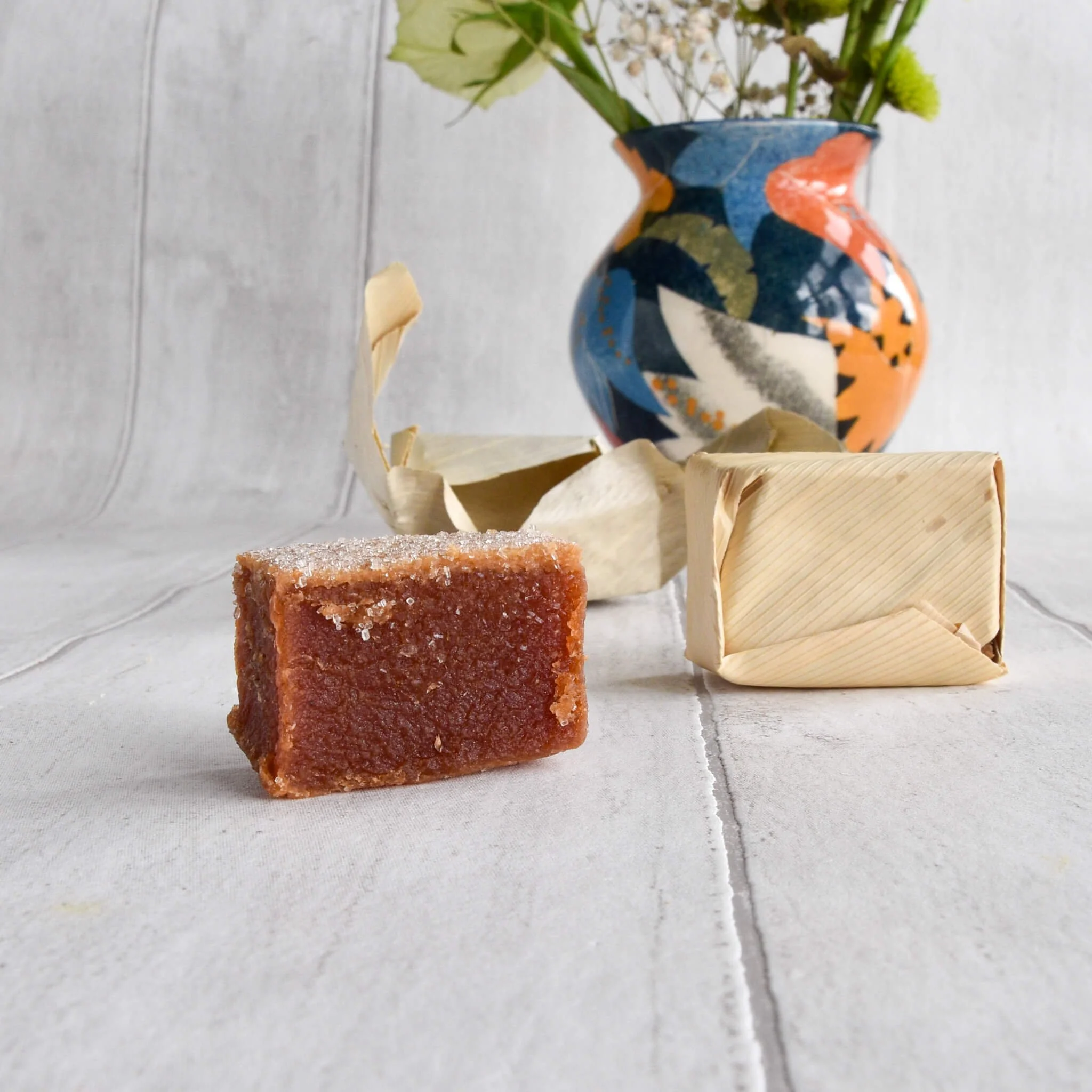 Guayaba / guava paste sweet in banana leaf with vase with flowers