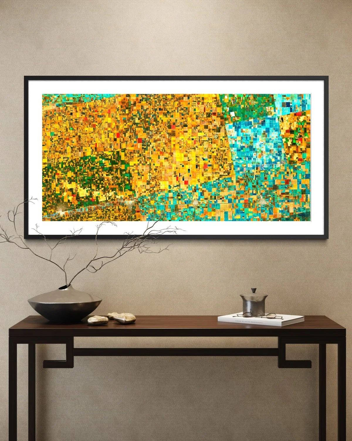 Colorful abstract art on a wall, with a black-and-white frame, above a wooden console table decorated with a black vase with branches, a small sculpture, and a white tray.