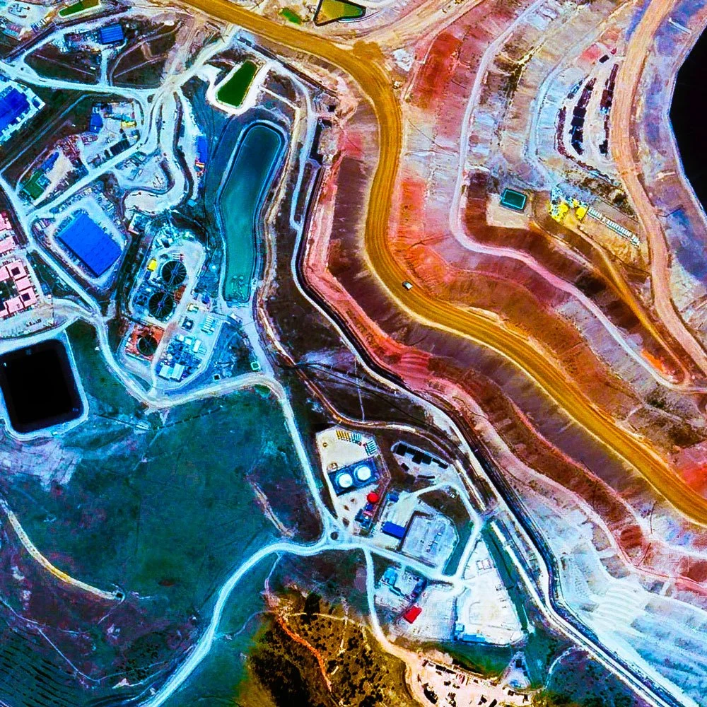 Ultradistancia Yanacocha Mine, Cajamarca, Peru — large-format satellite fine art by Federico Winer showing the mine as a luminous abstract composition of gold, blue, pink, green, and violet forms floating over a deep black background.
