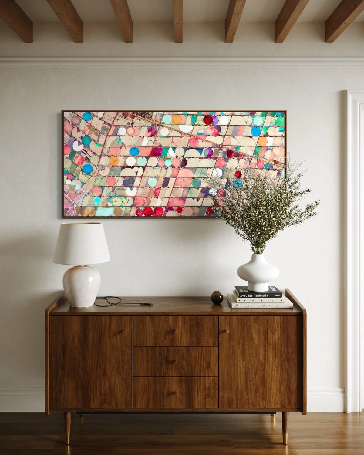 Ultradistancia Hartswater by Federico Winer installed above a contemporary sideboard, showing a panoramic satellite artwork of circular irrigation fields in soft pink, turquoise, cream, and red tones.