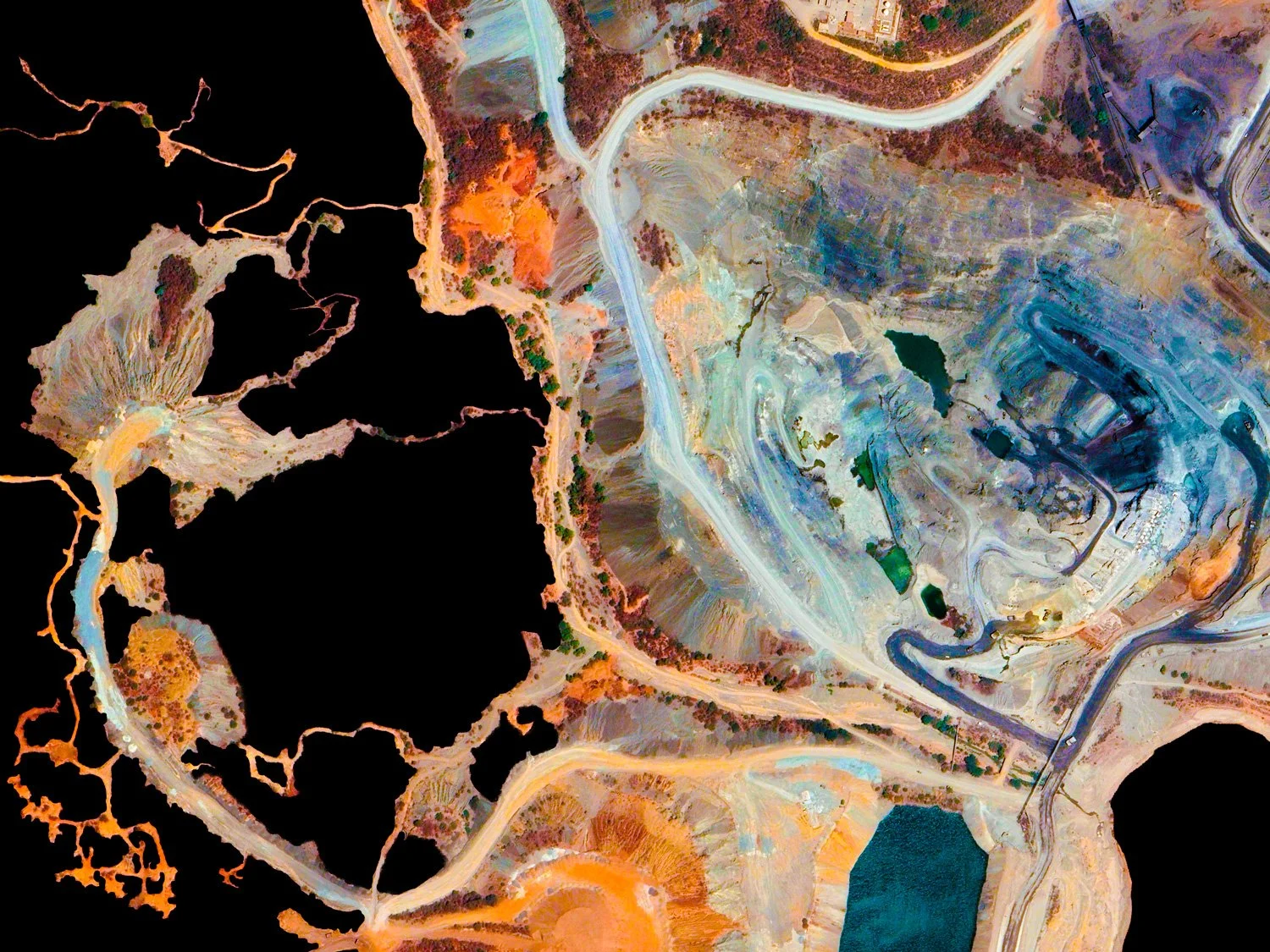 Colorful satellite image of a landscape showing lakes, roads, and varied terrain with different textures and colors.