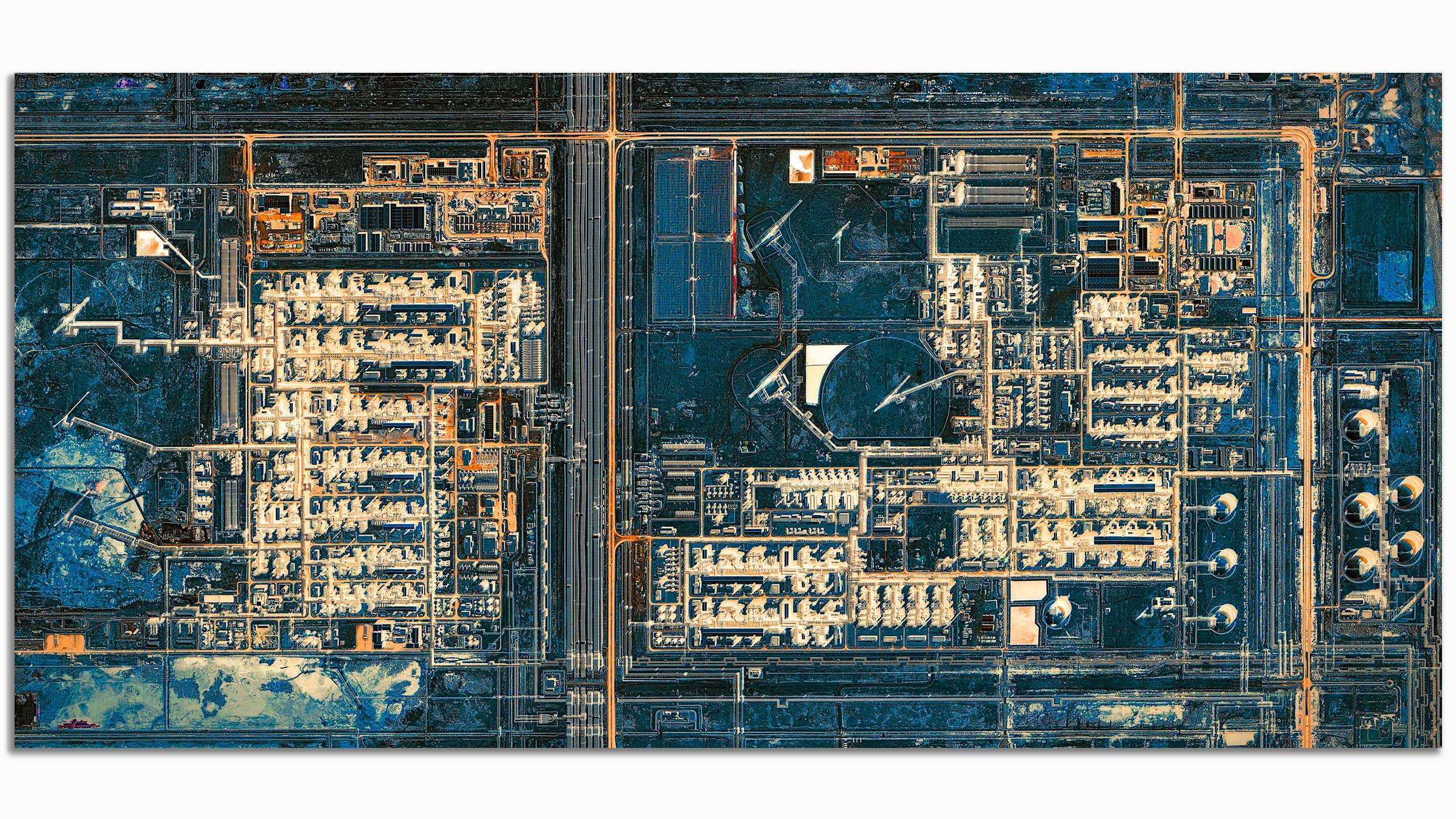 An aerial view of a city grid with roads, buildings, and large circular structures, possibly power plants or industrial facilities, featuring a combination of dark and bright colors.