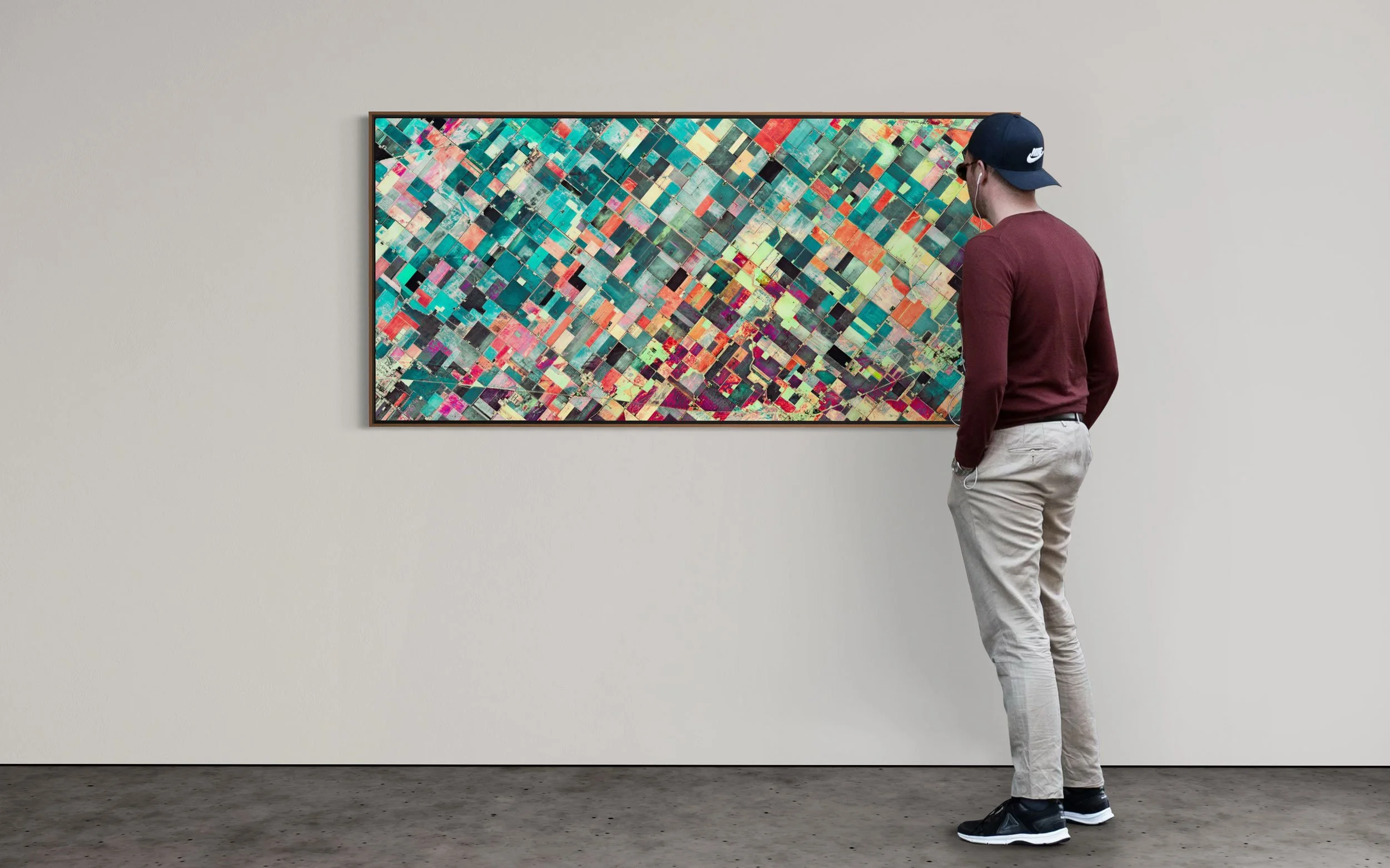 Large-scale satellite fine art artwork of agricultural land in Reese, Michigan, USA, shown on a gallery wall with a viewer standing in front of it.