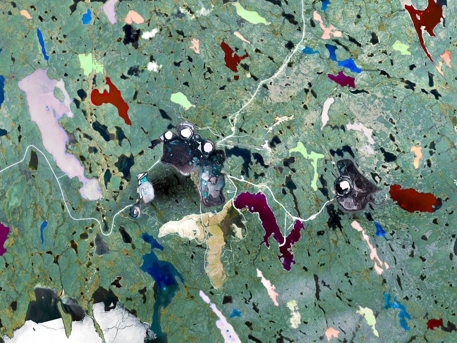 Satellite map showing a landscape with multiple lakes in various colors, roads, and some structures, with a focus on central area.