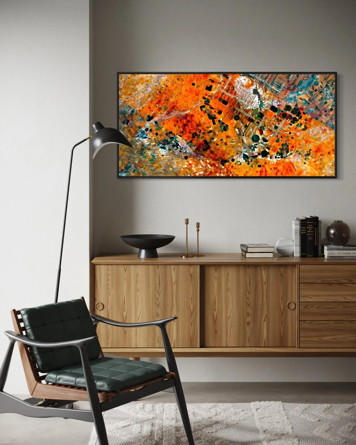 Modern interior with a wooden sideboard, abstract colorful painting, black and gold decor items, a black lamp, and a black leather chair with wooden arms in a well-lit room