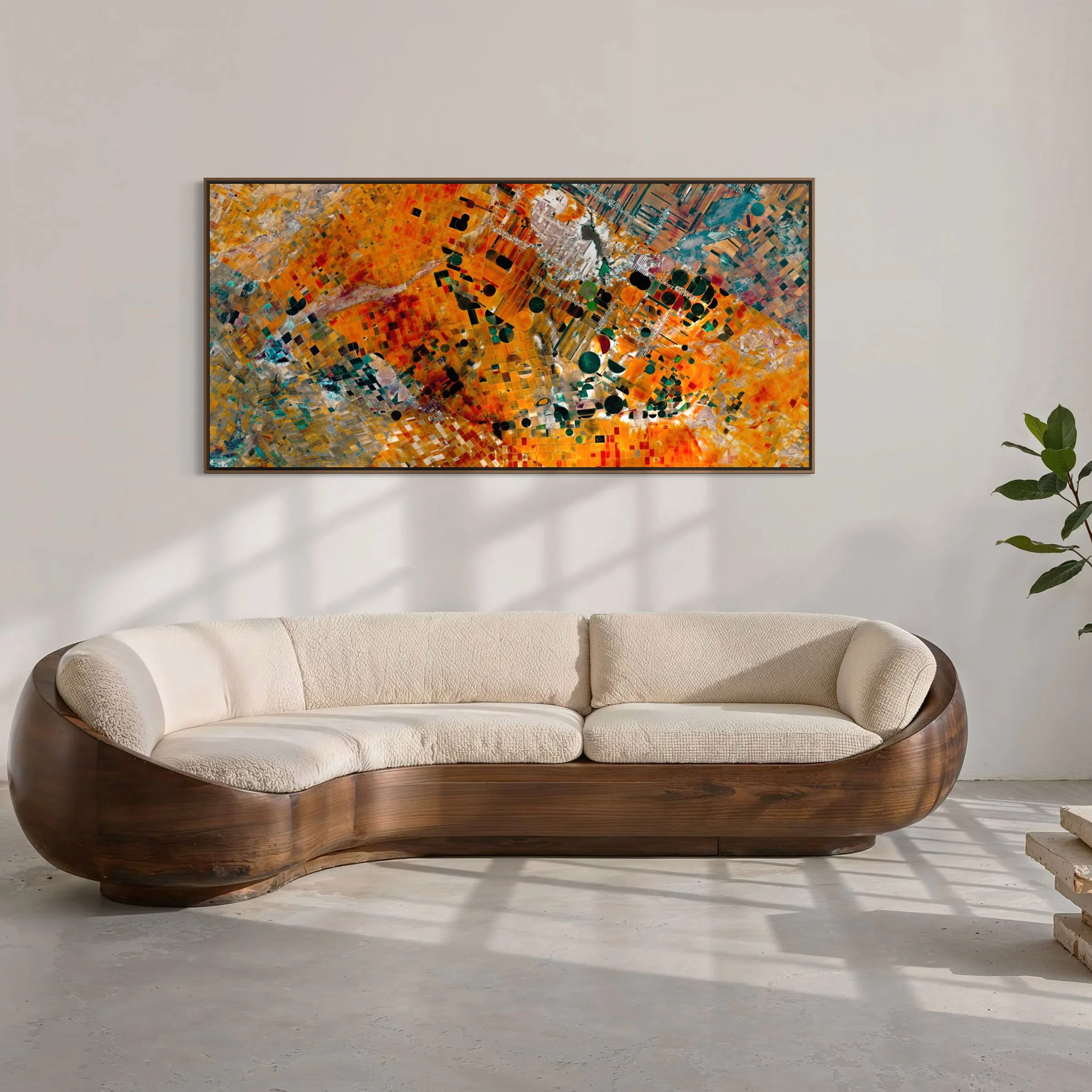 Framed panoramic satellite artwork of agricultural fields in Zacatecas, Mexico, displayed above a curved sofa in a contemporary interior.