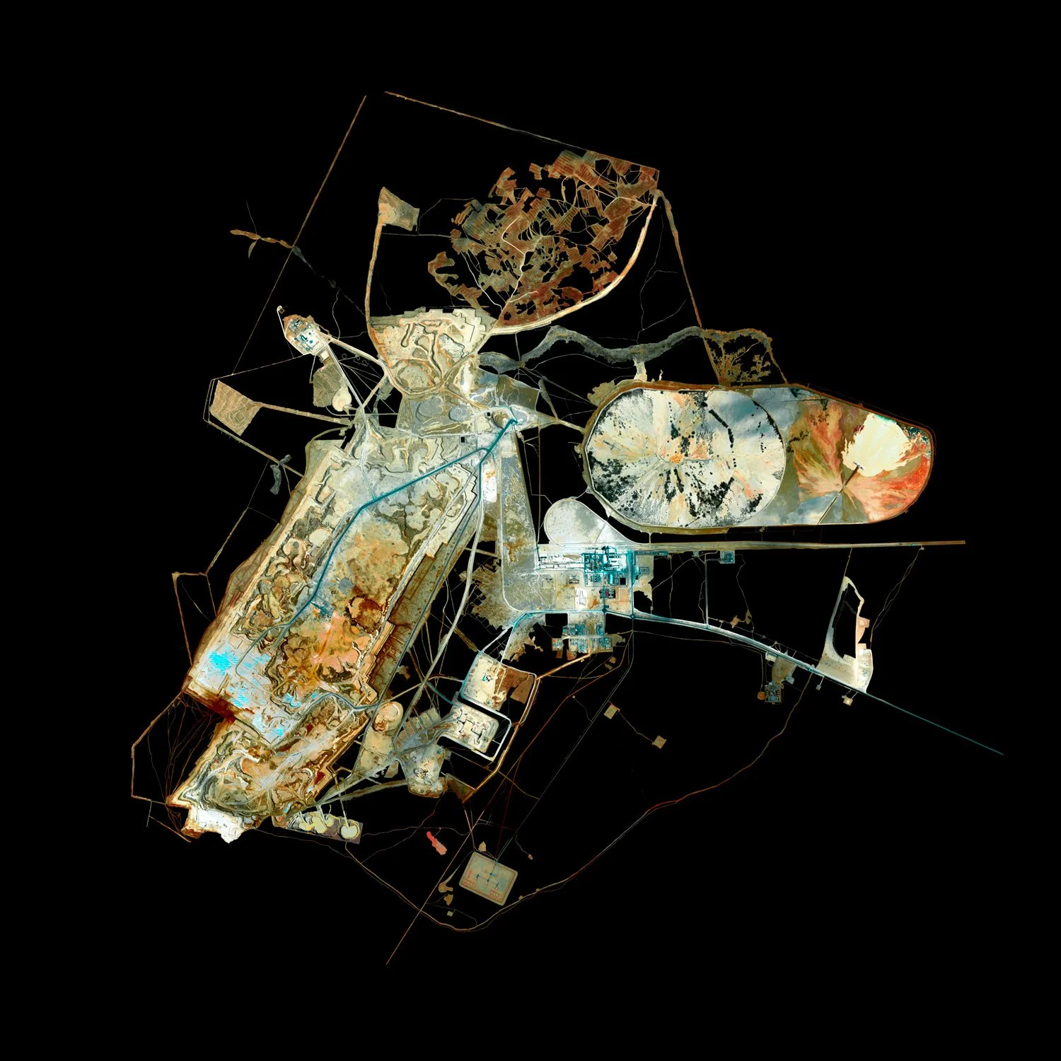 Satellite image of a large industrial facility or construction site with various buildings, roads, and circular structures, against a black background.
