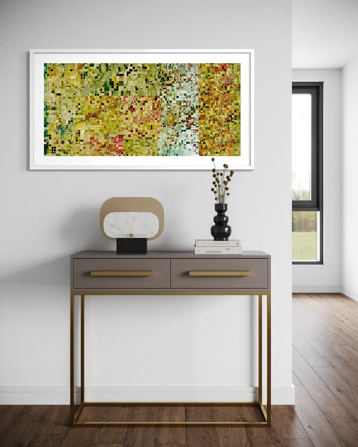 Modern living room with abstract colorful artwork on white wall, beige console table with gold accents, decorative vase, and books, natural light from large window.