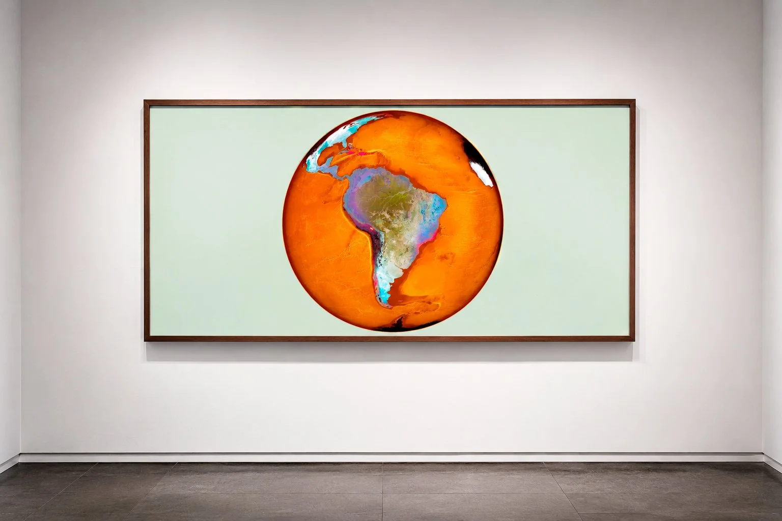 Artistic depiction of the Earth with North and South America, framed and displayed in a gallery.