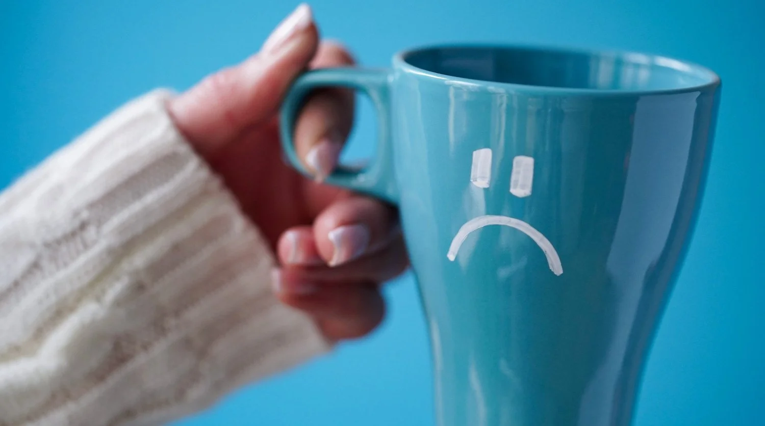 woman holding a sad blue mug