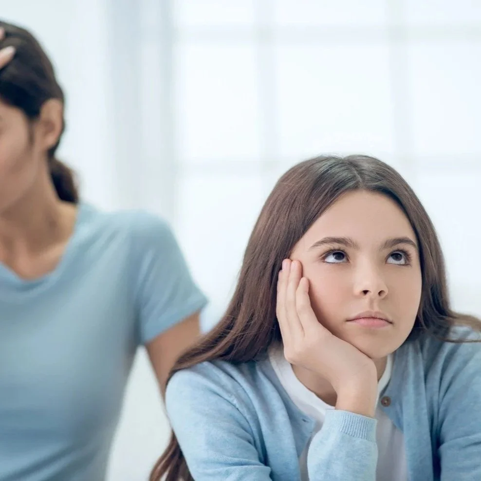 teenager sitting annoyed with parent