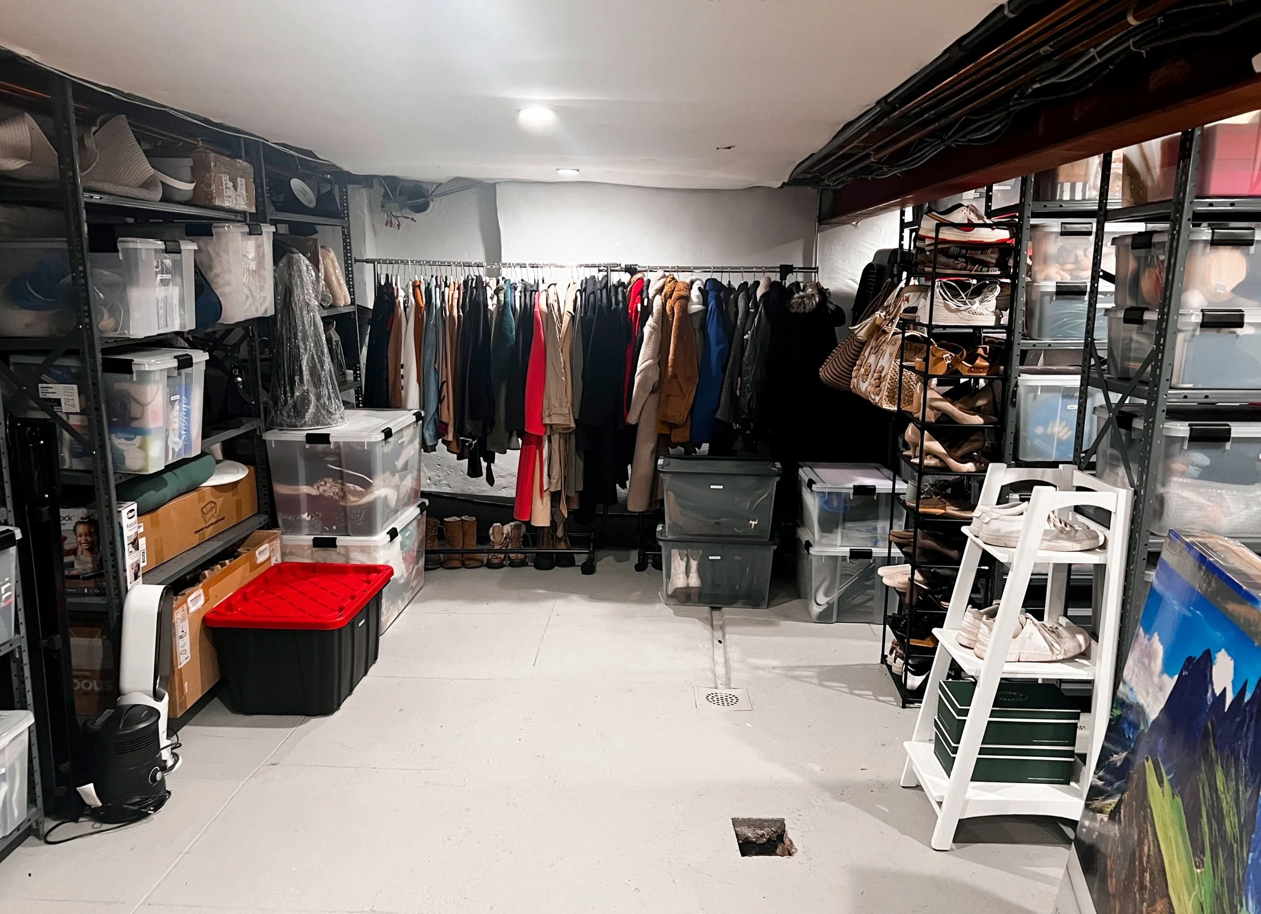 Organized basement space with racks for waterproof bins and raised hanging racks