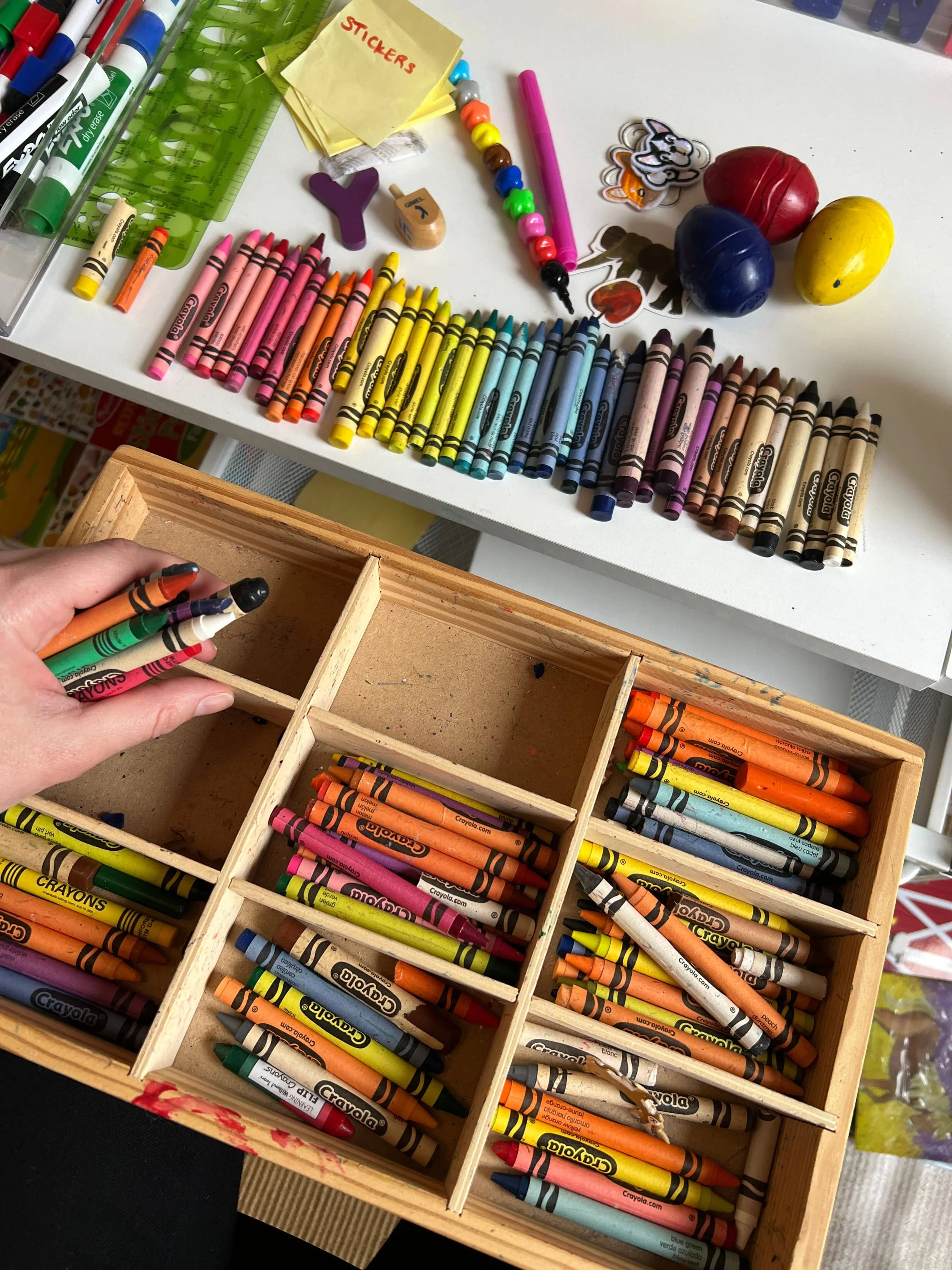 Crayons being organized into a single drawer